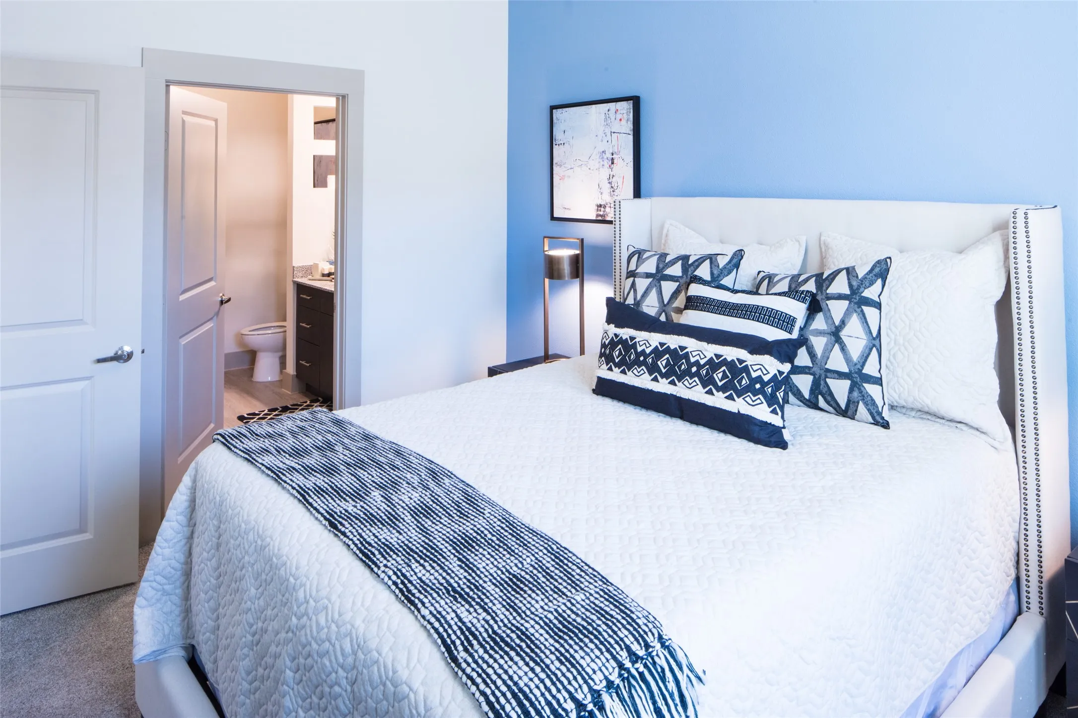 Bedroom featuring ensuite bathroom and carpet flooring