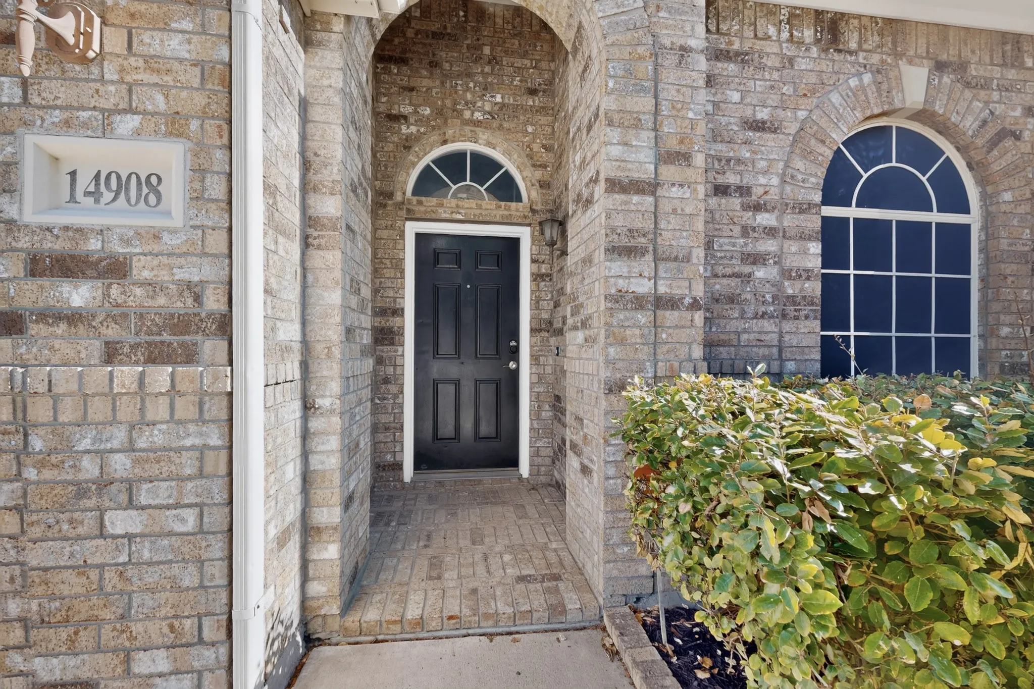 Brick facade with arched entry and complementing arched window