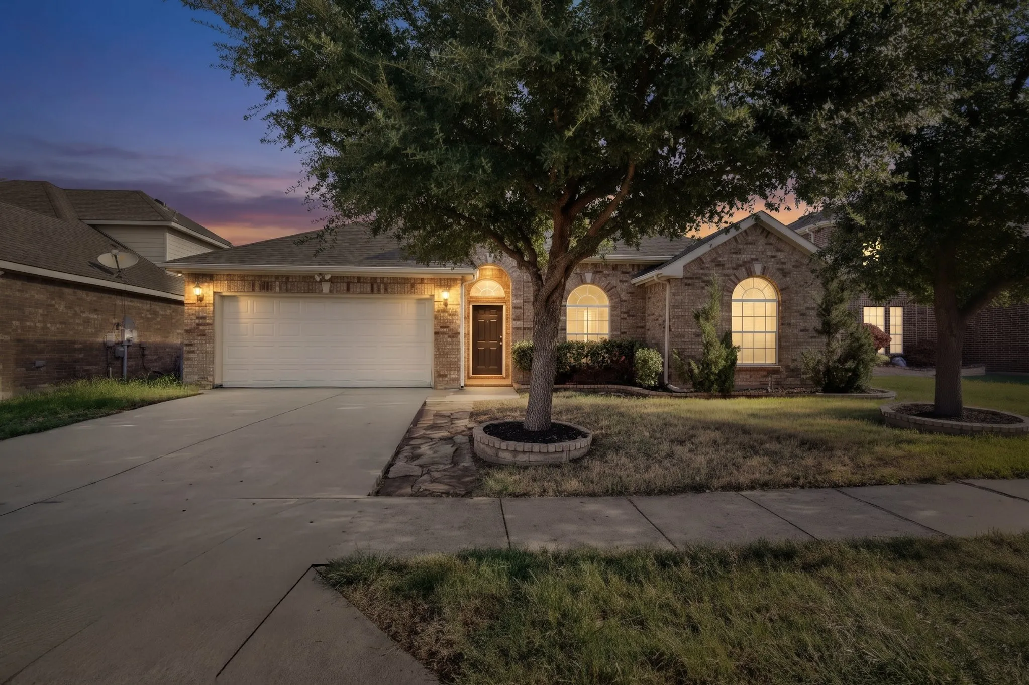 Brick facade residence with an attached garage and concrete driveway