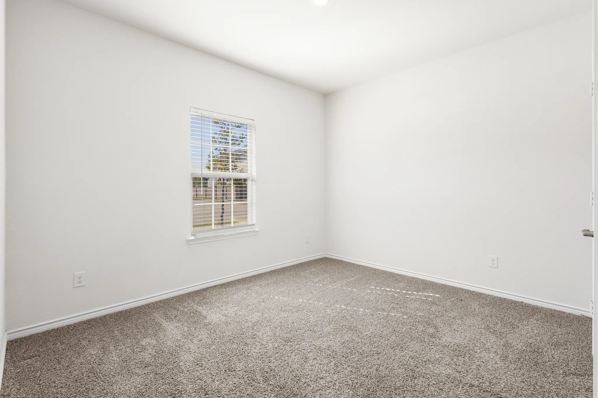 Carpeted room with white walls, a single window with blinds, and recessed lighting