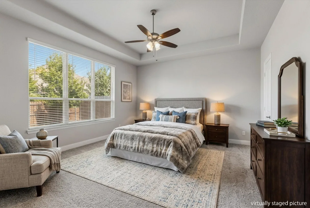 Tray ceiling with a ceiling fan, light gray wall paint, large windows with blinds, and light-colored carpeting