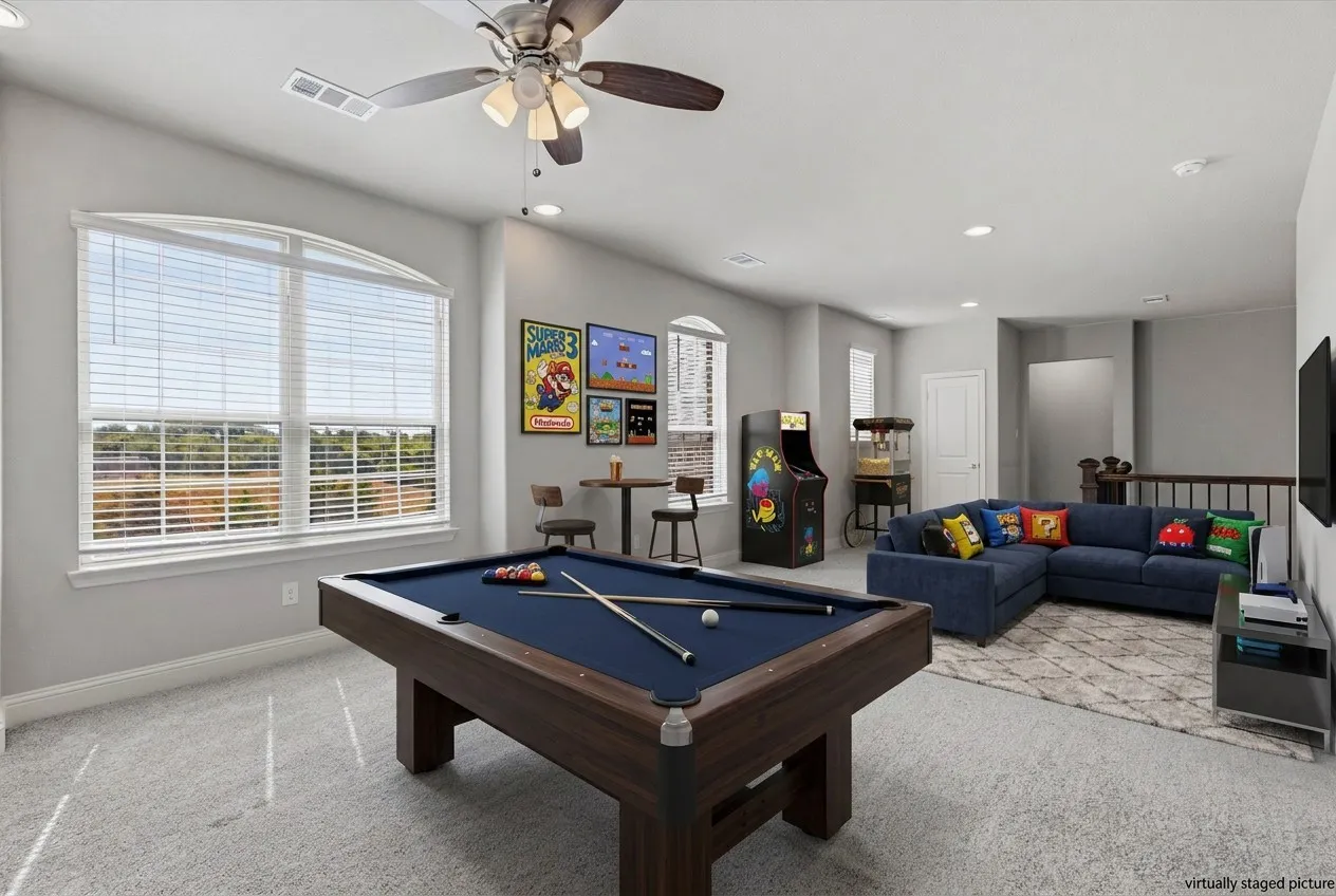 Expansive room featuring light gray carpeting, multiple windows with blinds, a ceiling fan, and recessed lighting