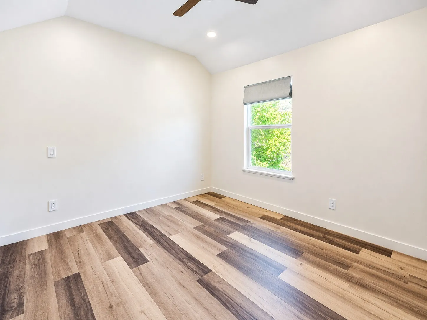 Vaulted ceiling with recessed lighting and a ceiling fan