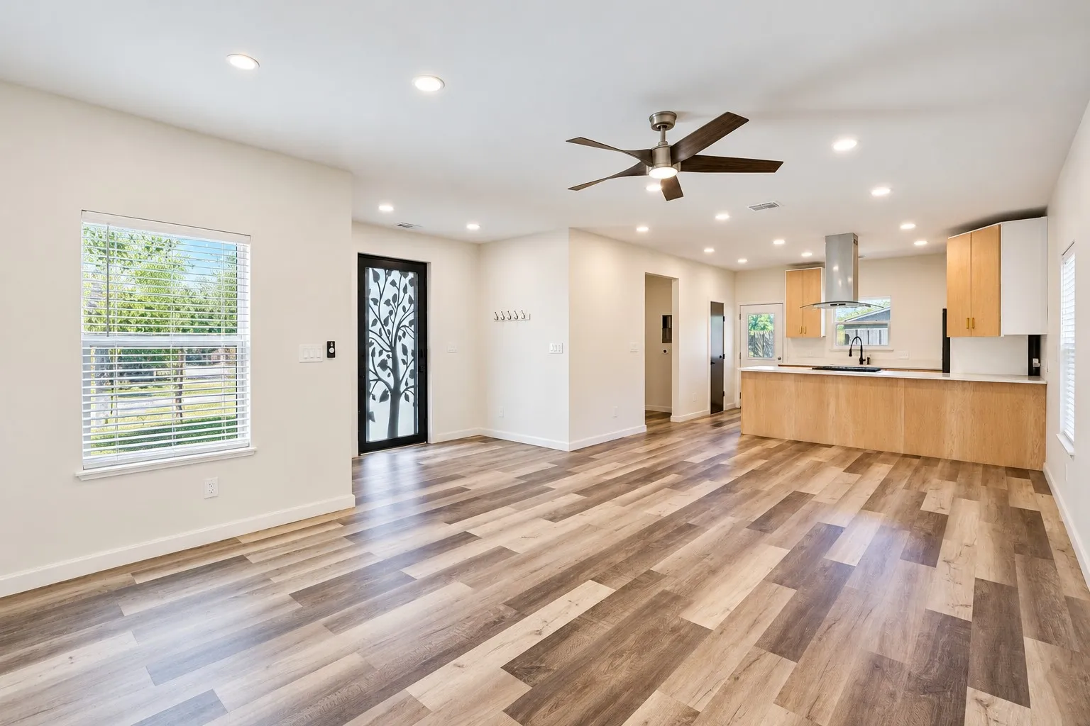Recessed lighting throughout, wood-finish flooring, ceiling fan, contemporary kitchen cabinetry, and stainless steel range hood