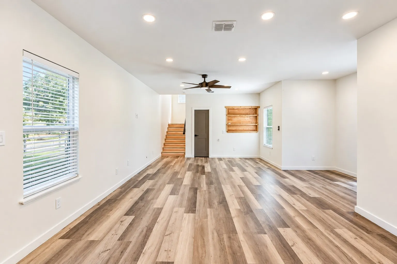 Open-concept living area featuring wood-finish flooring, recessed lighting, and a ceiling fan