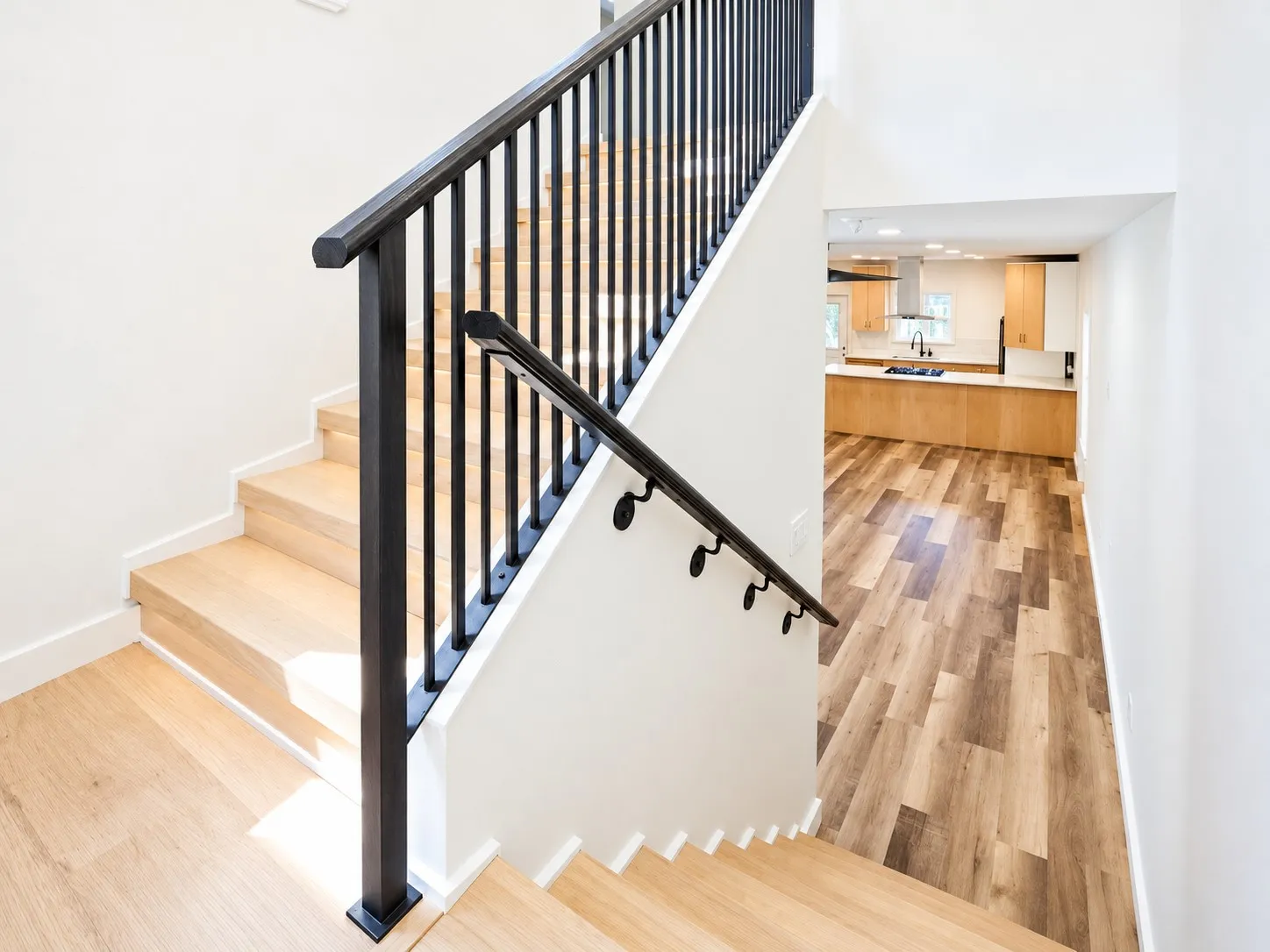 Hardwood staircase with black metal balusters and handrail