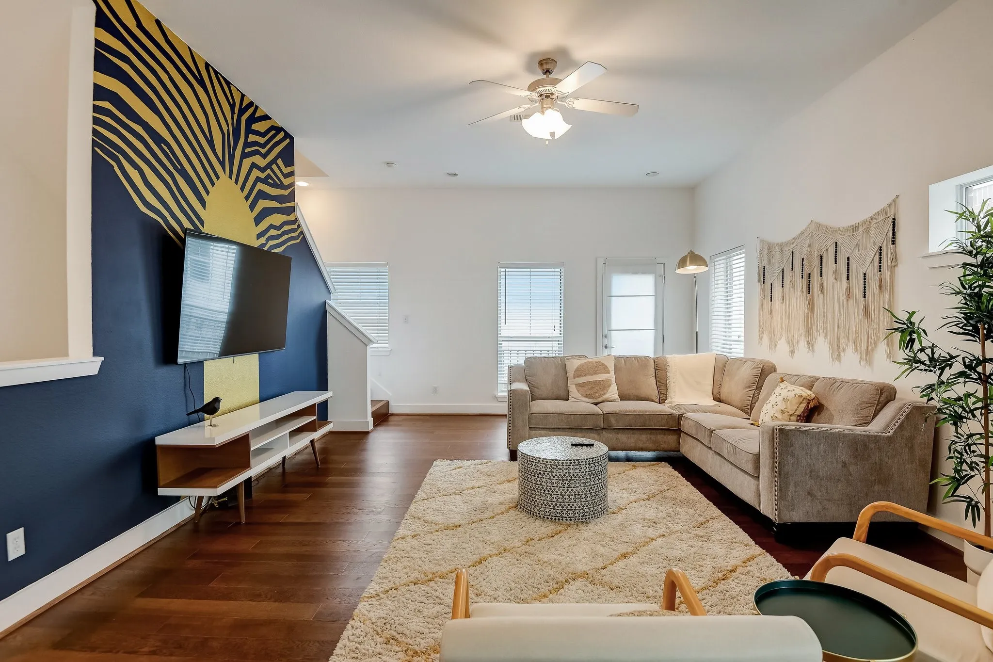 Living area with a ceiling fan, dark wood finished floors, stairway, and baseboards
