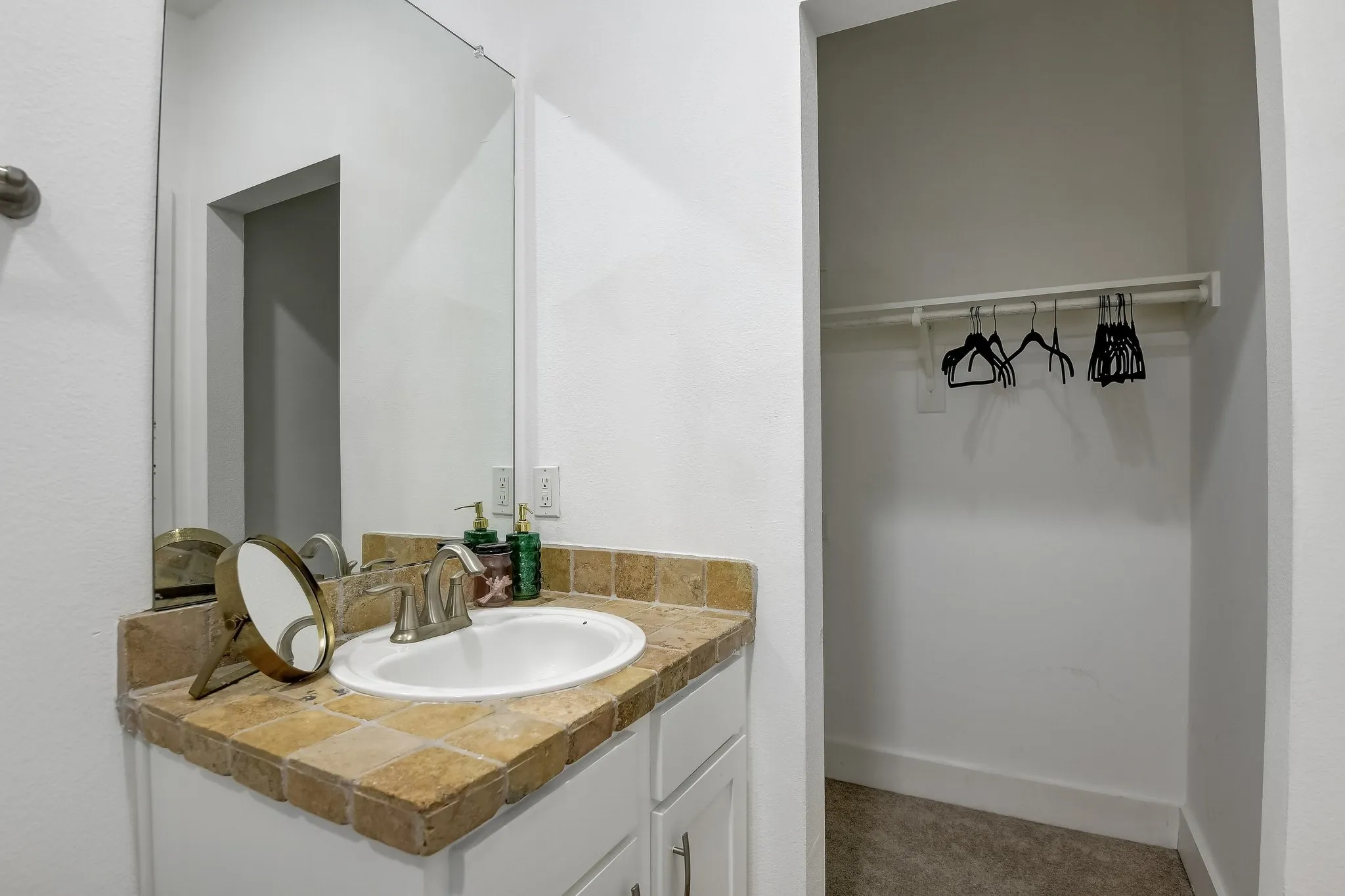 Bathroom with vanity and a spacious closet