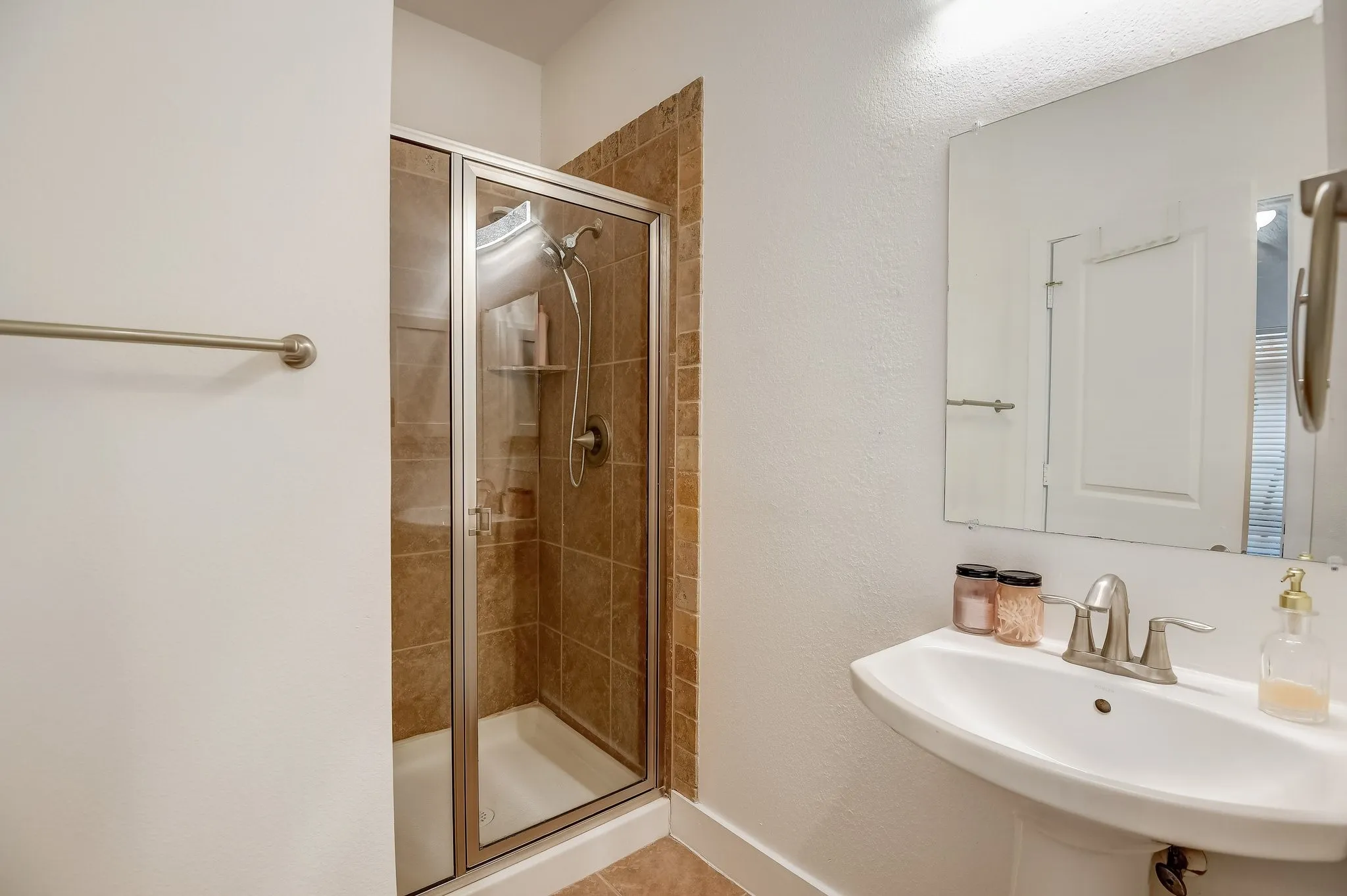Bathroom featuring a sink, a stall shower, and tile patterned floors
