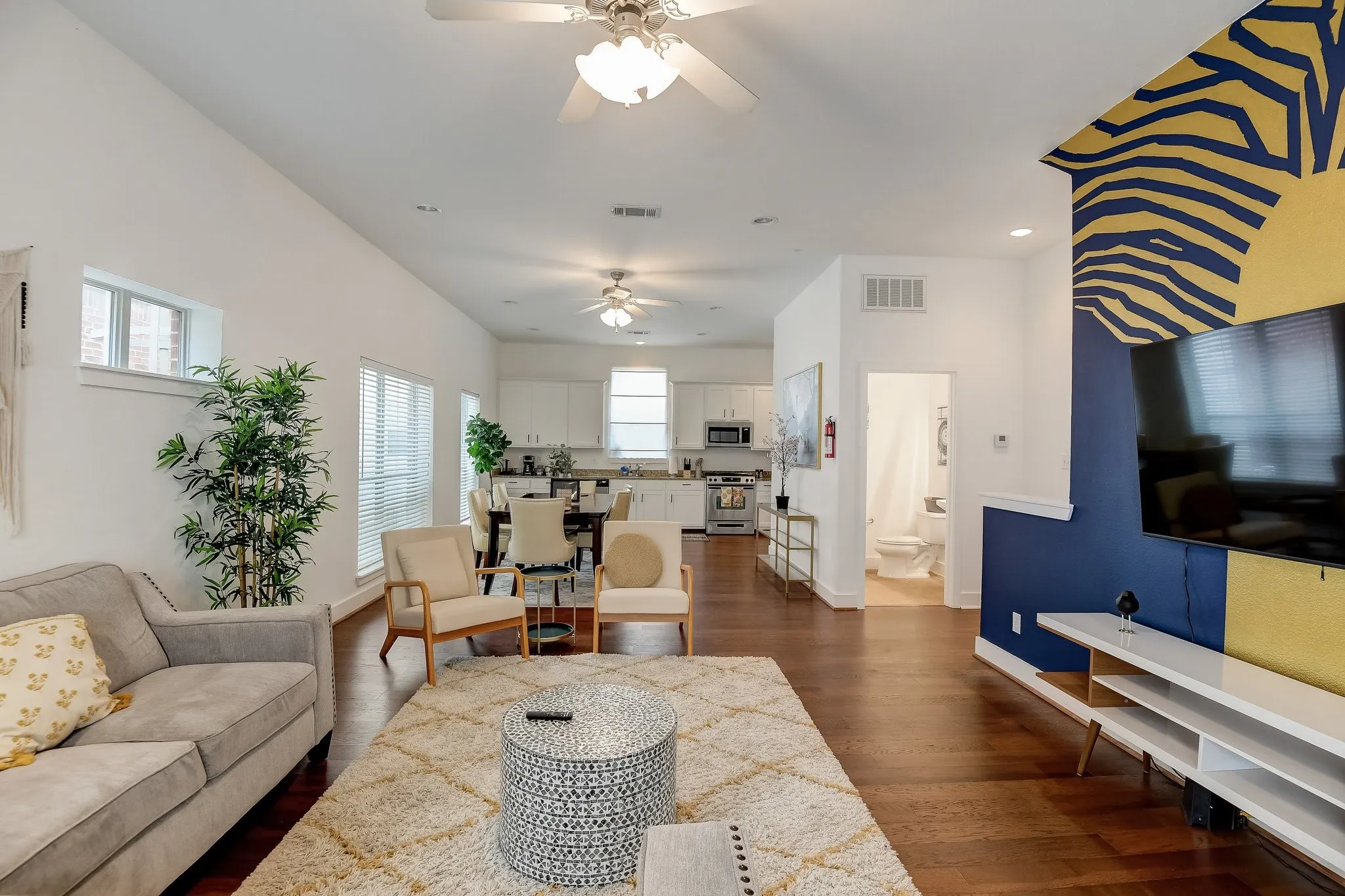 Living room with ceiling fan, baseboards, dark wood-type flooring, and recessed lighting