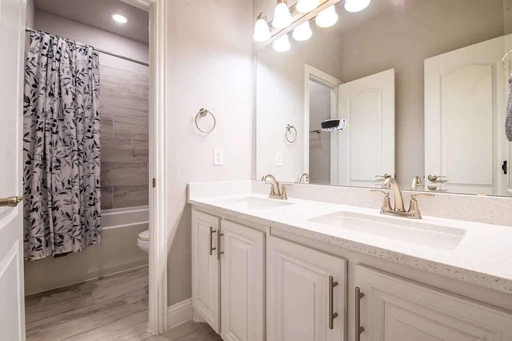 Dual vanity with integrated sinks, light-toned countertops, and brushed nickel fixtures