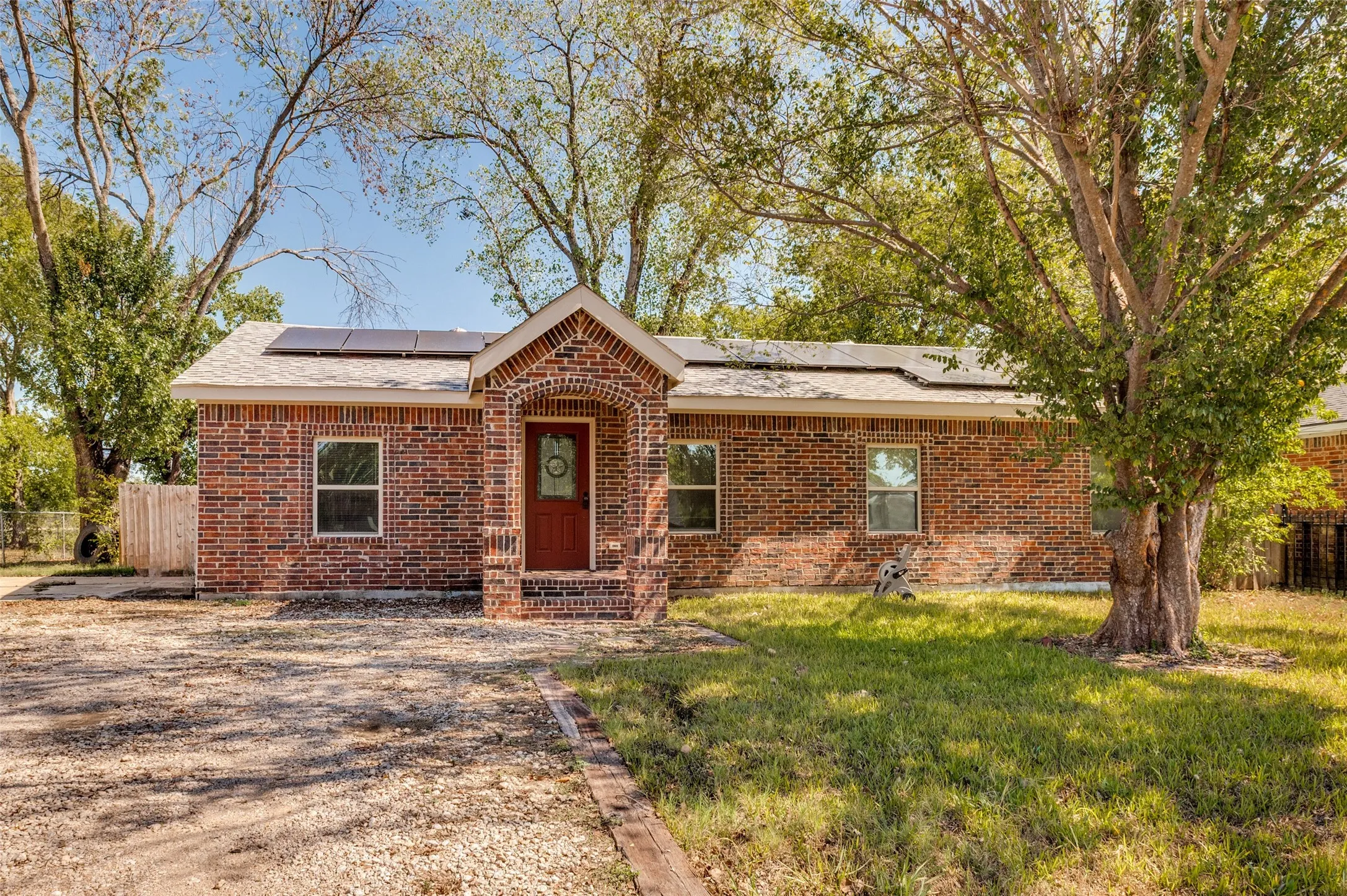 Brick exterior with an arched entryway and dark wood door