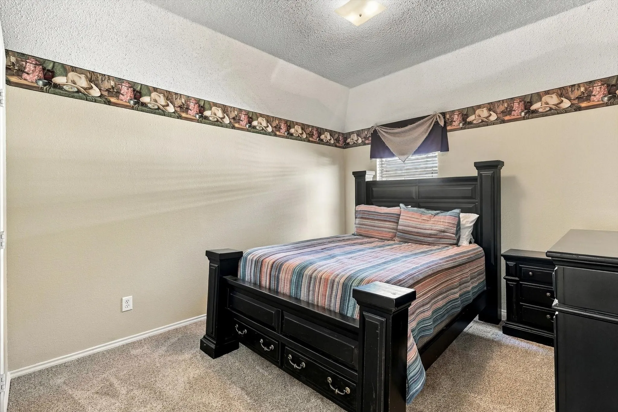 Textured carpeting, neutral wall paint, and a decorative border