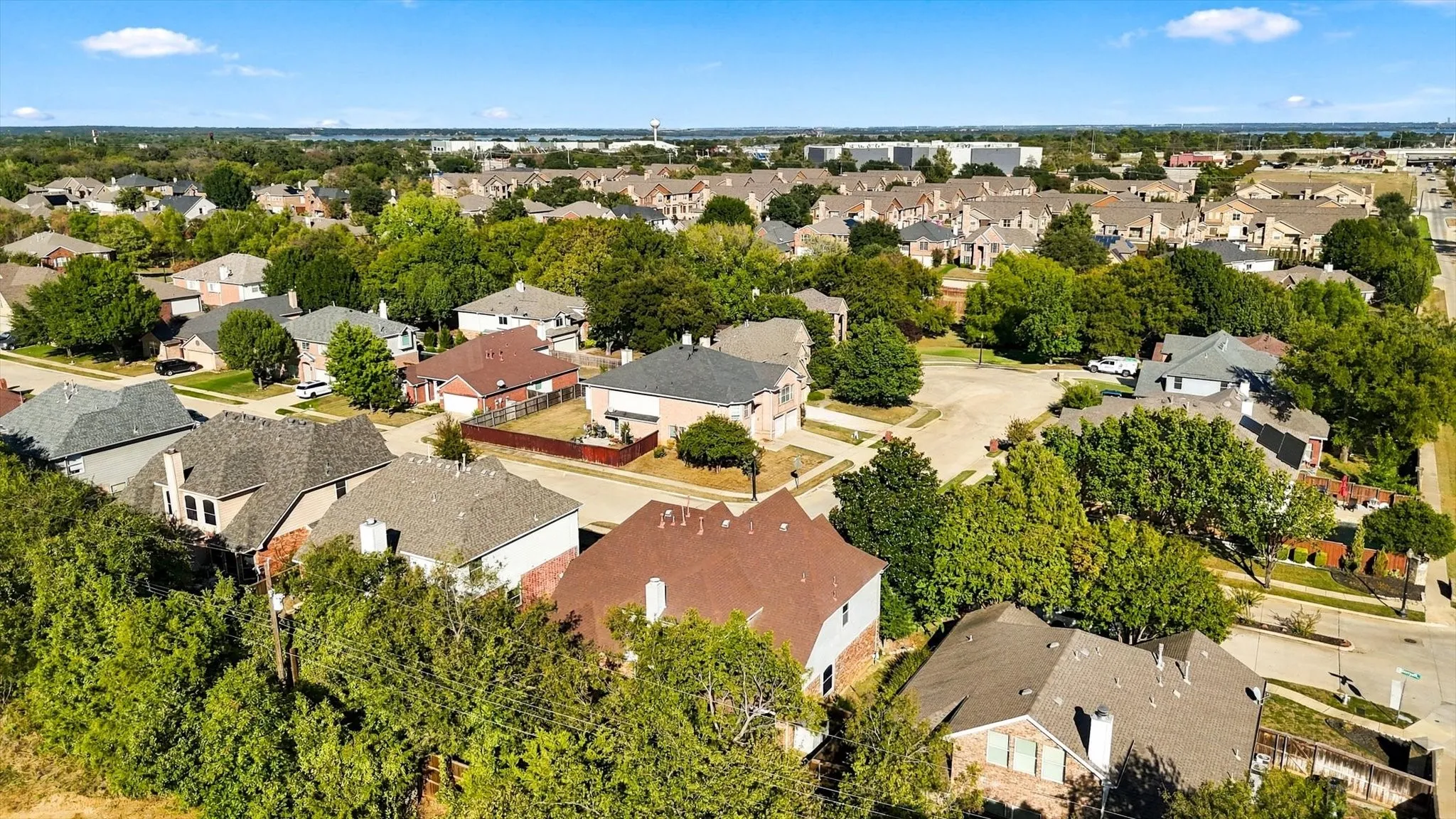 Neighborhood setting featuring mature trees, residential streets, and varied single-family homes