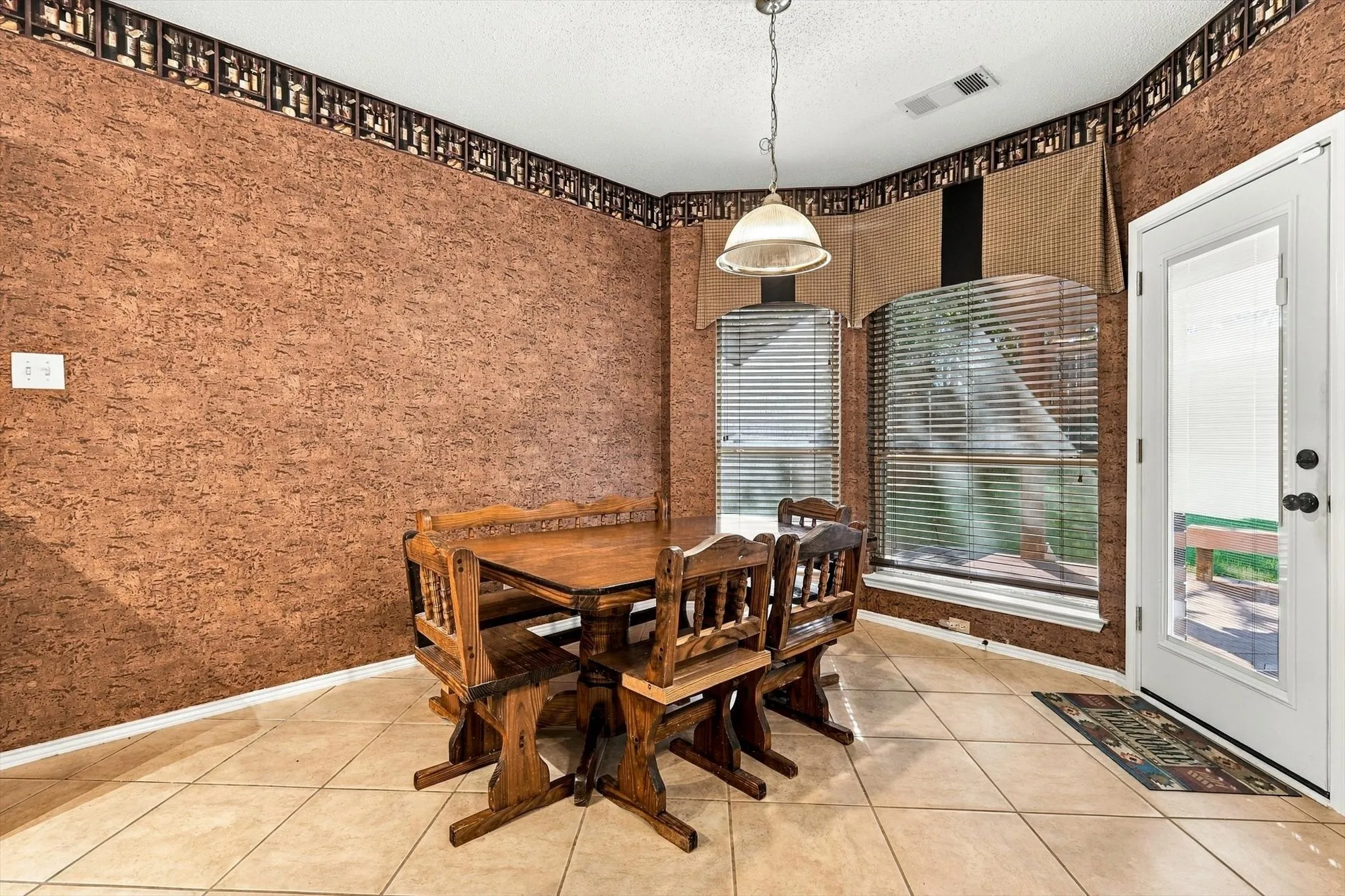 Tiled flooring, textured wall covering, and a ceiling-mounted light fixture