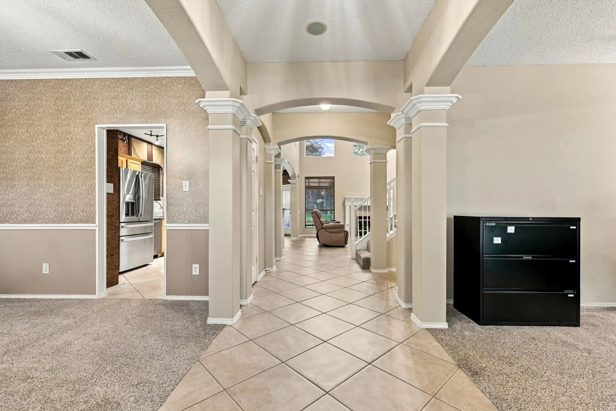 Archway entry with decorative columns leading to a tiled corridor