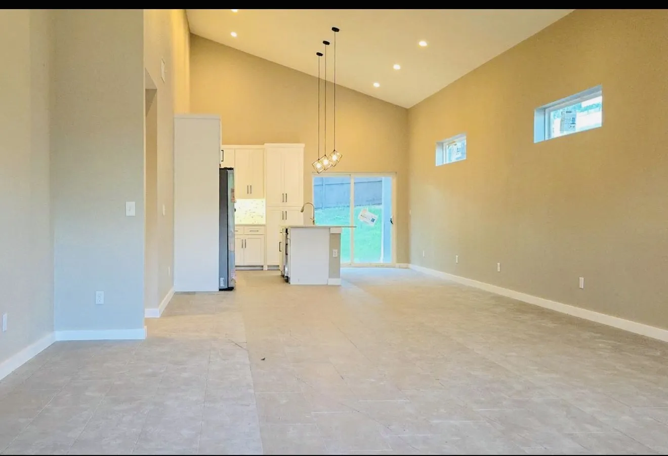 Vaulted ceiling with recessed lighting and a contemporary pendant fixture