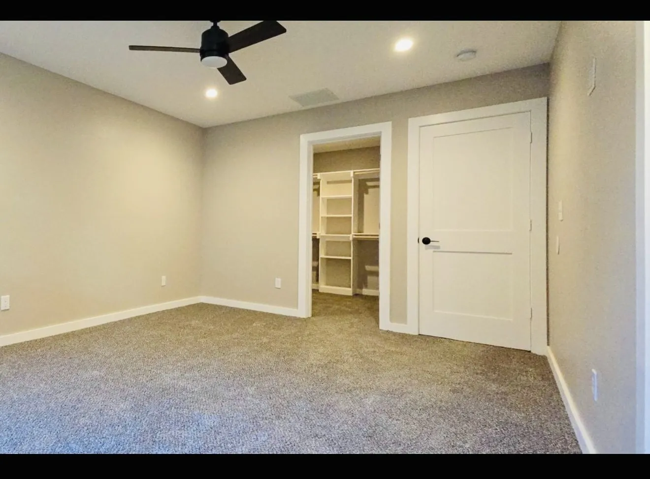 Spacious room featuring neutral carpeting, a ceiling fan, recessed lighting, and a closet with built-in shelving