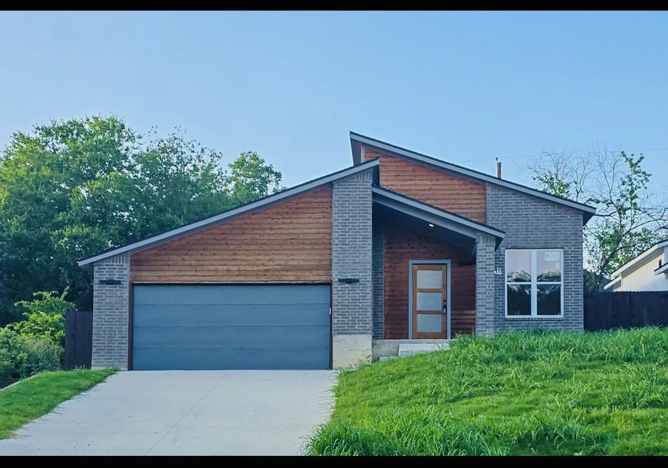 Contemporary facade featuring grey brick and wood-finish siding