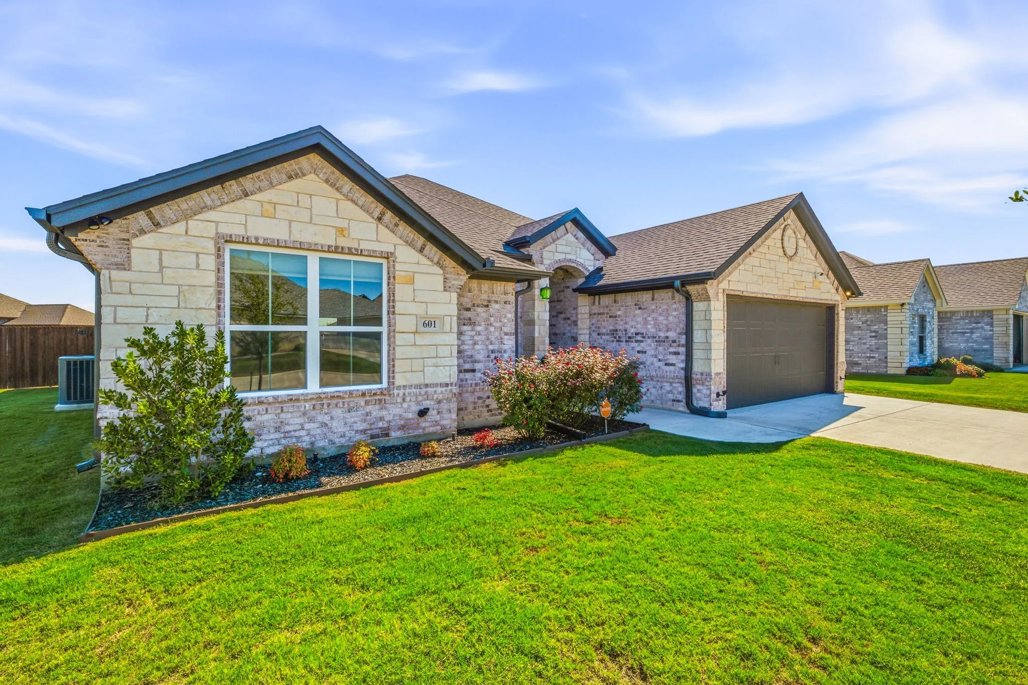 Stone and brick exterior with dark trim and a gabled roof