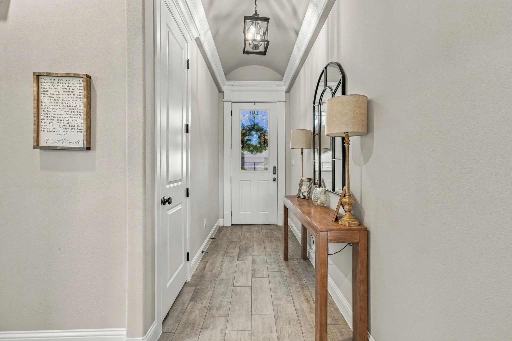Archway ceiling with recessed lighting, wood-finish flooring, and a white paneled door
