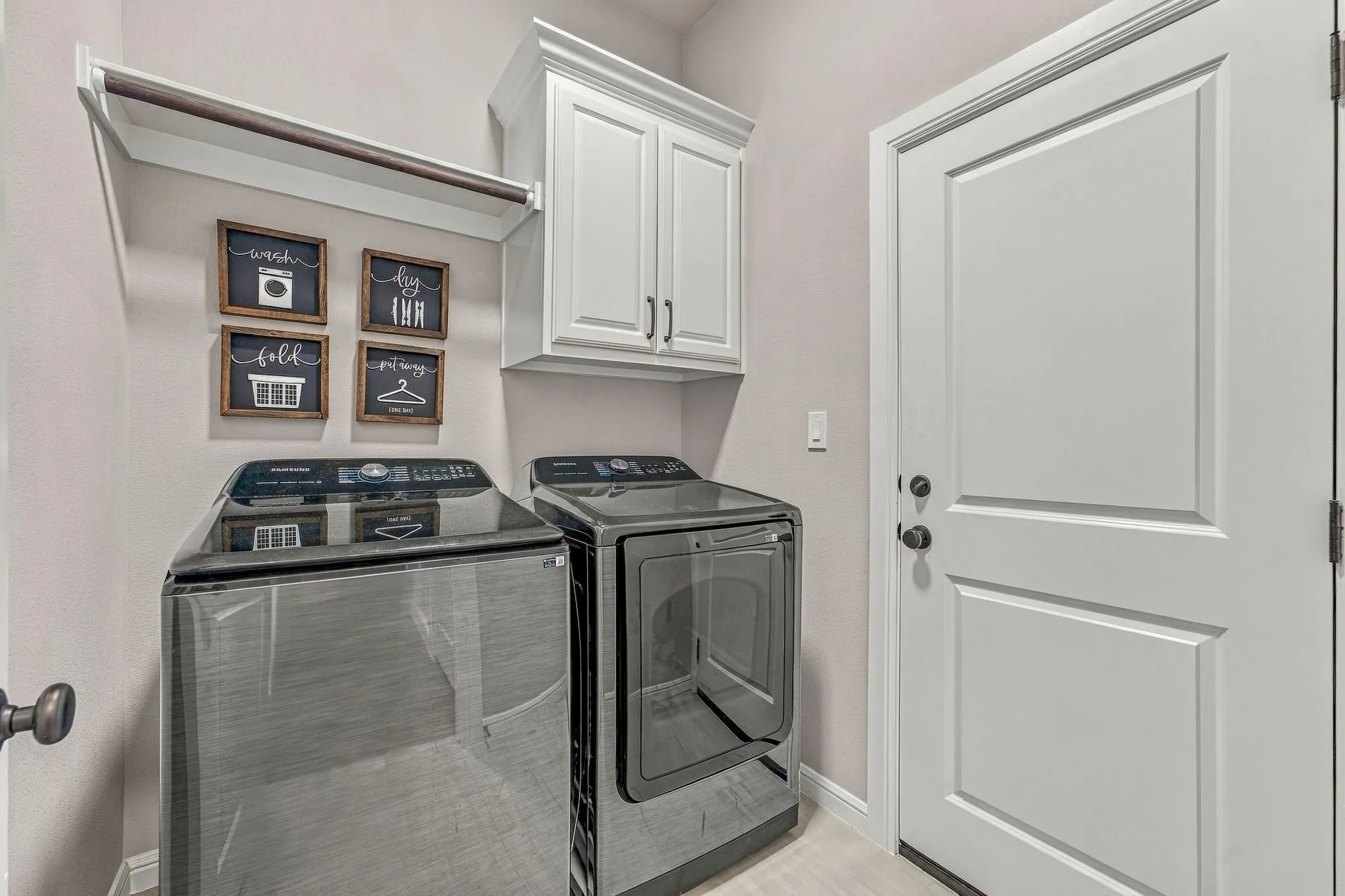 White shaker-style cabinetry, recessed panel door, and a built-in hanging rod