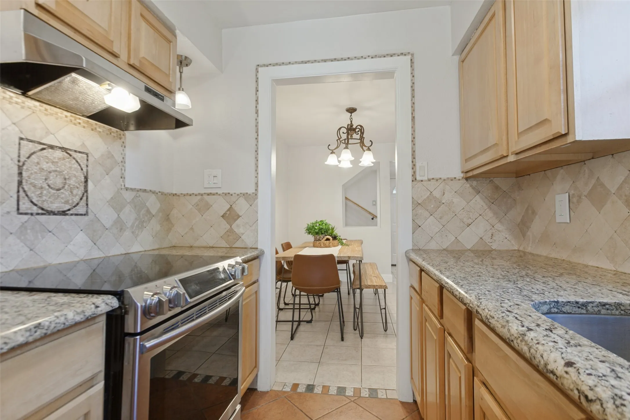 351 Vally Park Dr. - Updated kitchen featuring Spanish tile flooring, granite countertops, beautiful mosaic tile backsplash and stainless steel appliances, including the refrigerator.