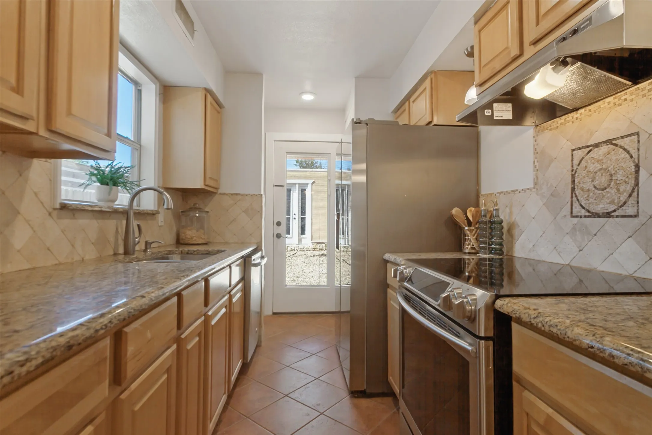 351 Vally Park Dr. - Updated kitchen featuring Spanish tile flooring, granite countertops, beautiful mosaic tile backsplash and stainless steel appliances, including the refrigerator.