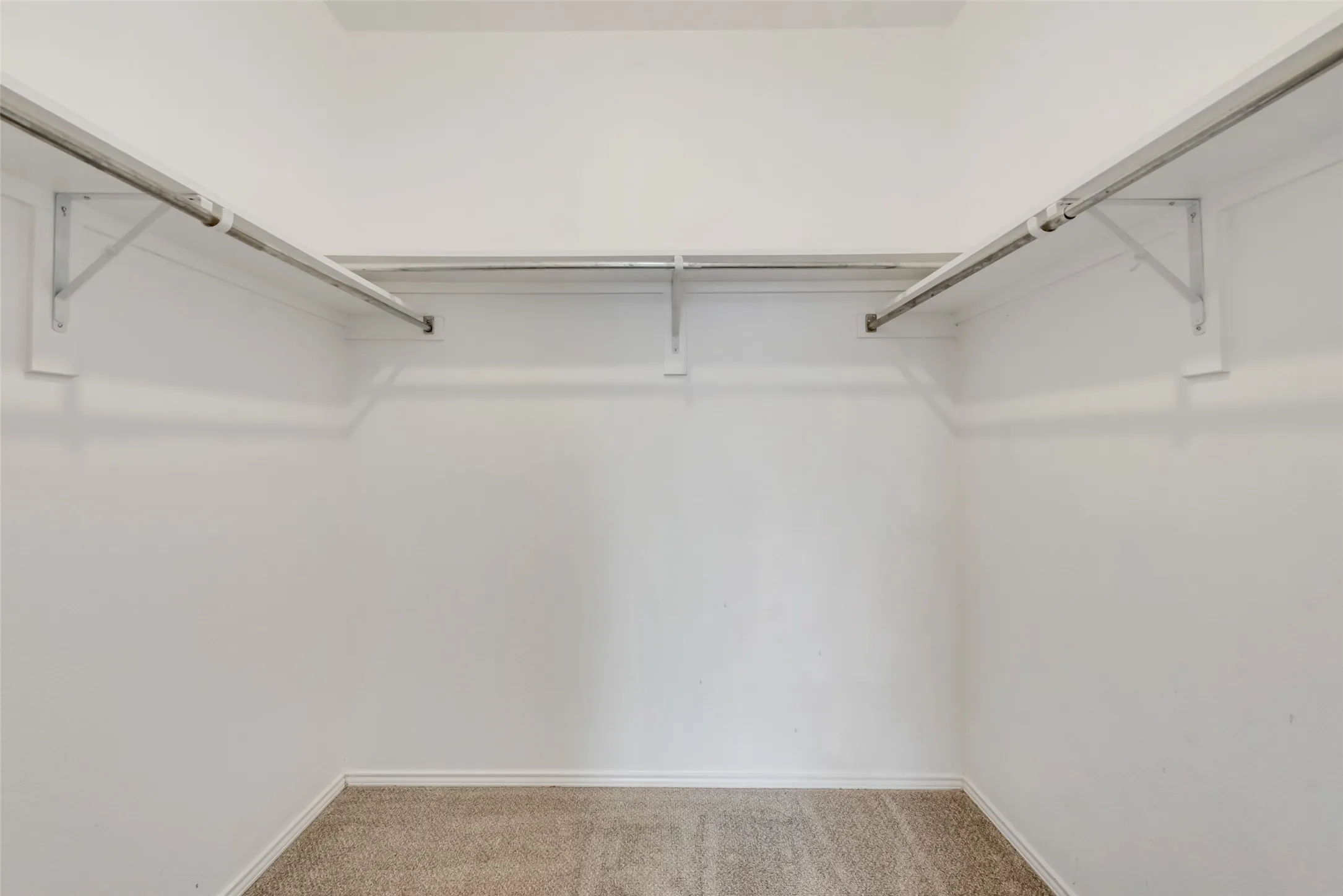 Built-in hanging rods, upper shelving, and carpeted flooring