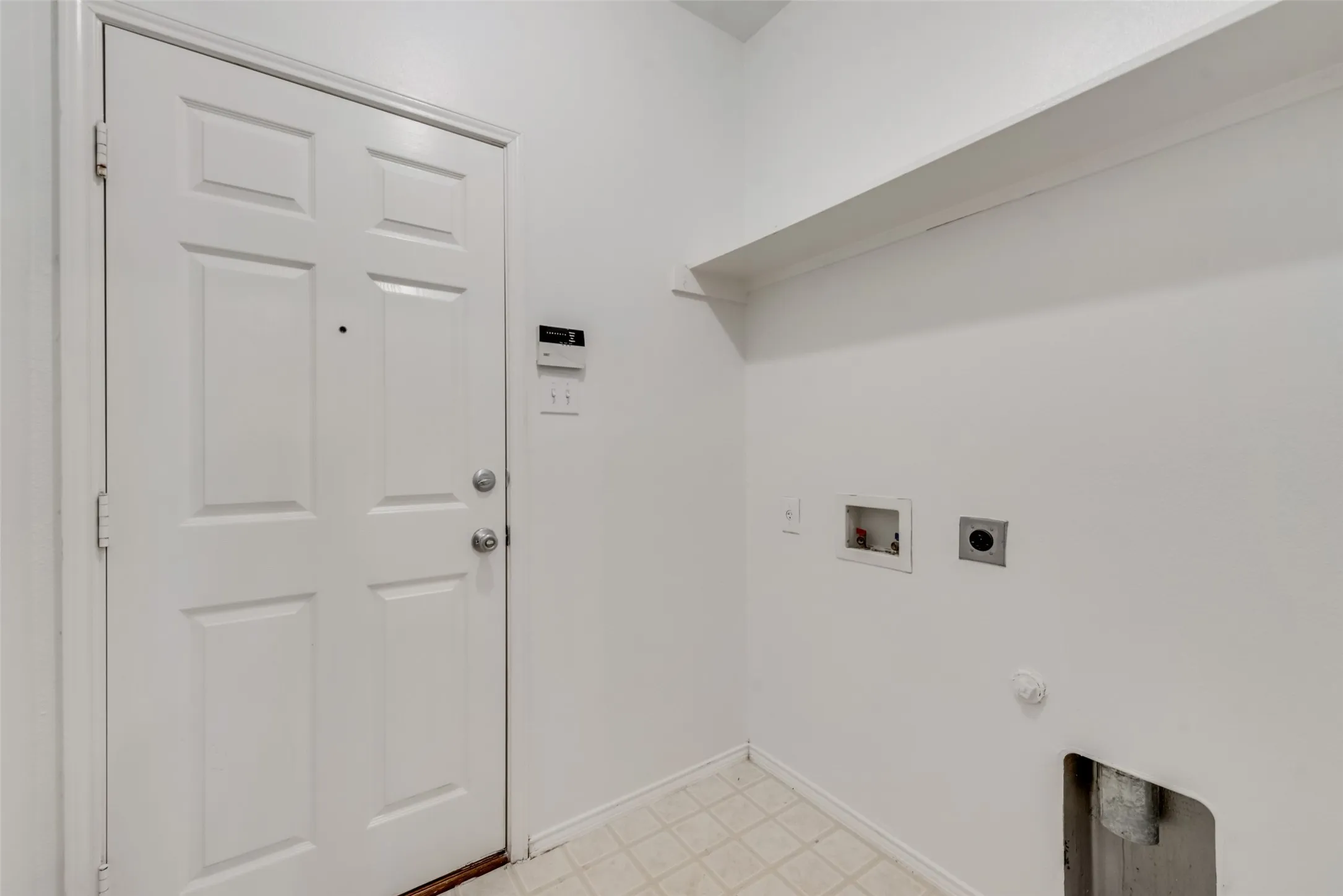 Utility space featuring a paneled door, built-in shelving, and vinyl flooring