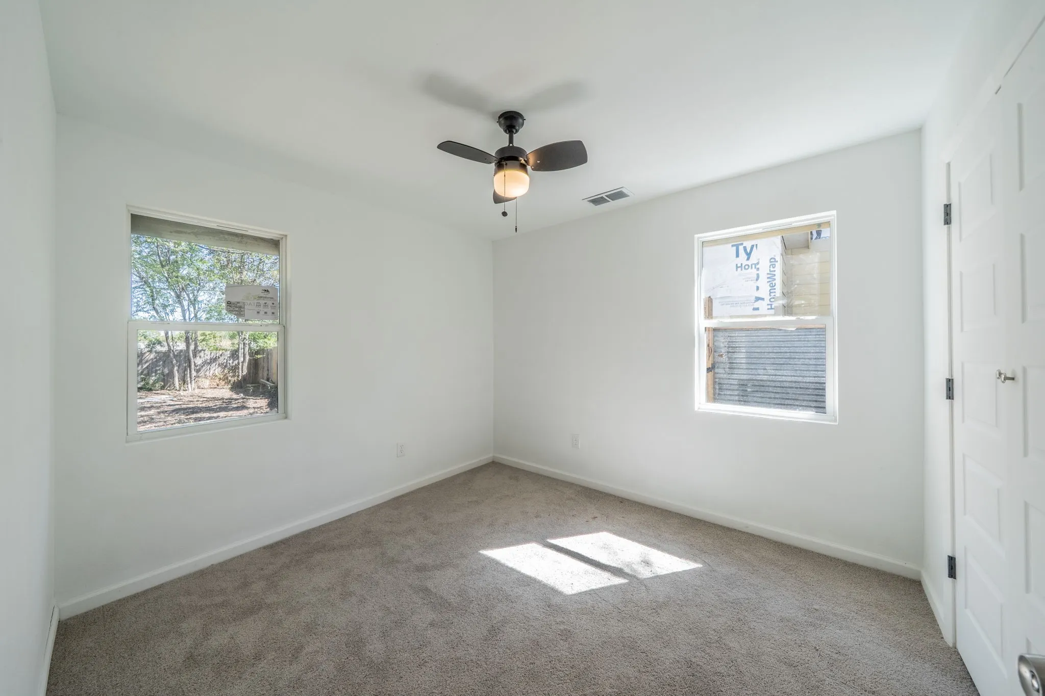 Plush carpeting, neutral wall finish, and a ceiling fan with integrated lighting