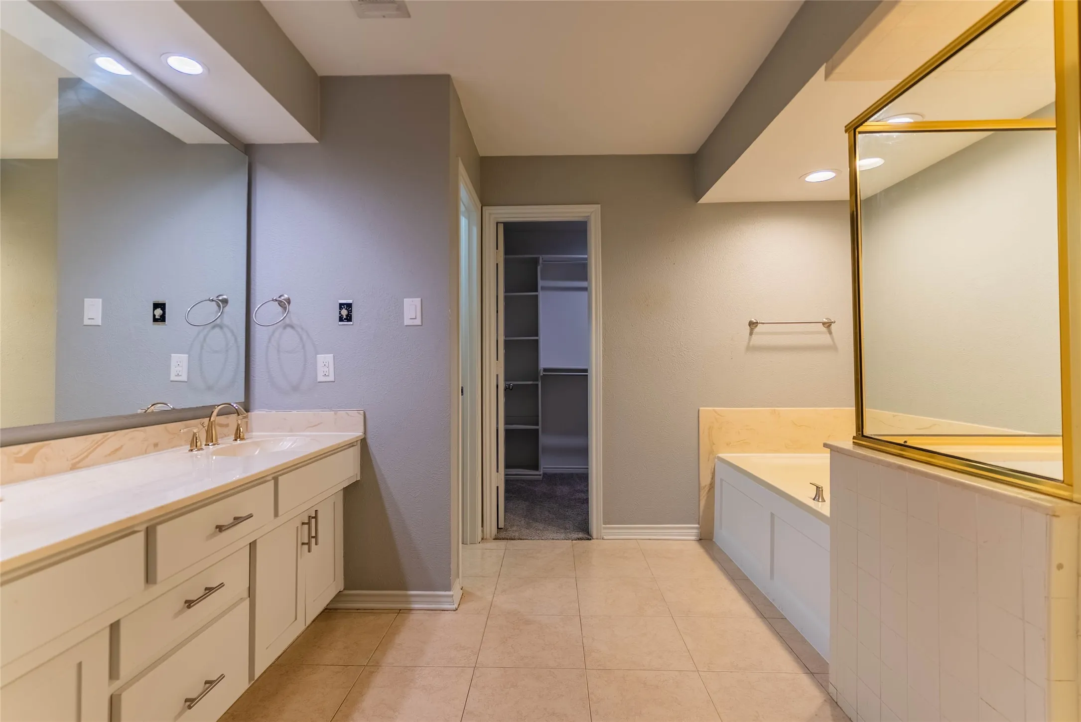 Dual vanity with undermount sinks, gold-finish faucets, and integrated cabinetry