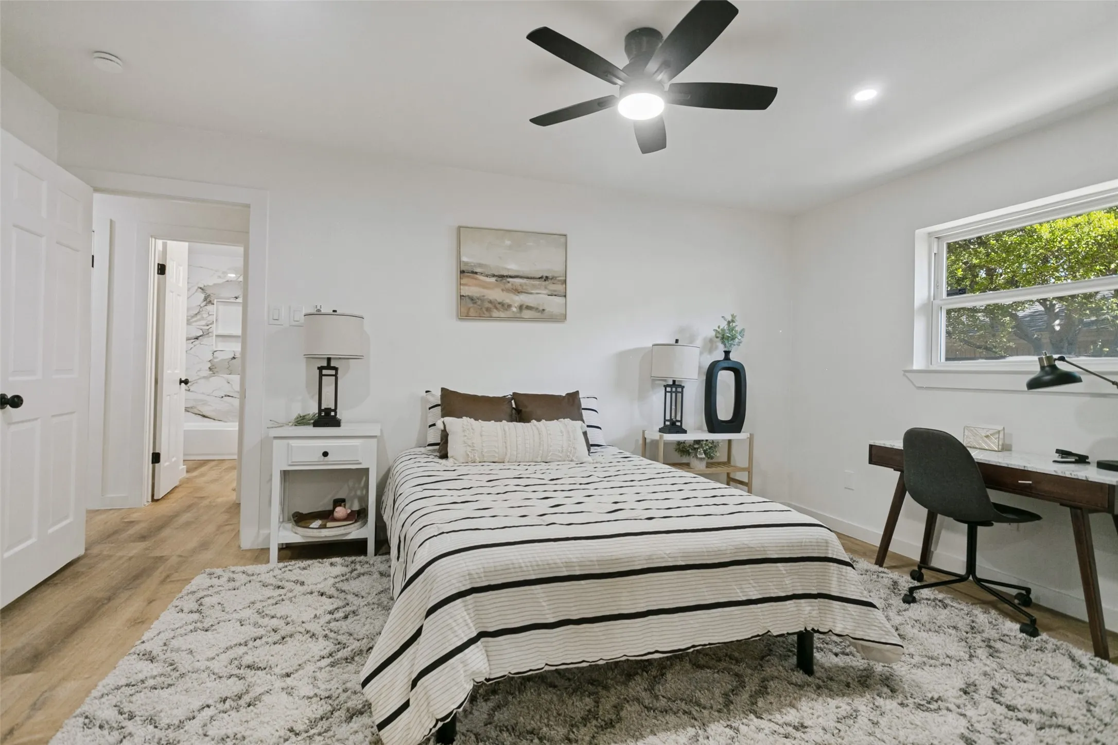 Recessed lighting, a ceiling fan with integrated lighting, wood-finish flooring, and white interior doors with black hardware