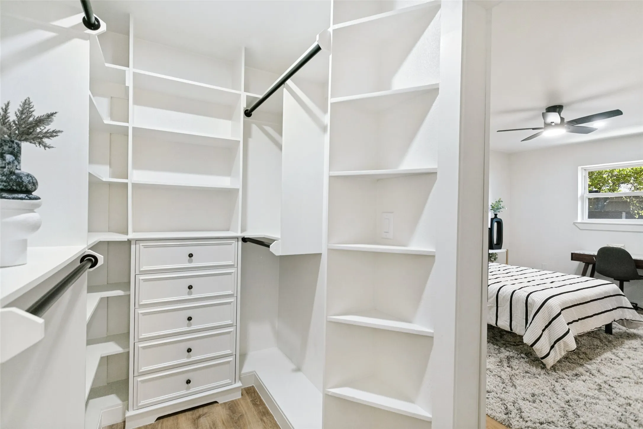 Custom closet system featuring built-in shelving, hanging rods, and a five-drawer dresser