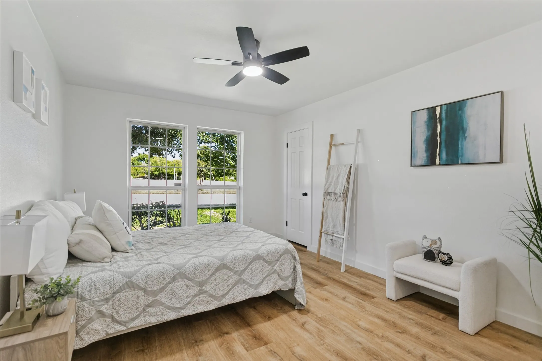 Crisp white walls, wood-finish flooring, and a contemporary ceiling fan