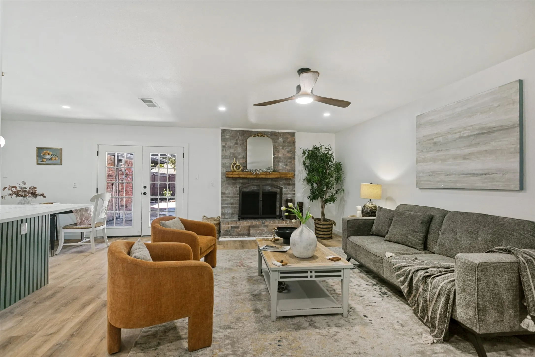 Recessed lighting, wood-finish flooring, white walls, and a ceiling fan