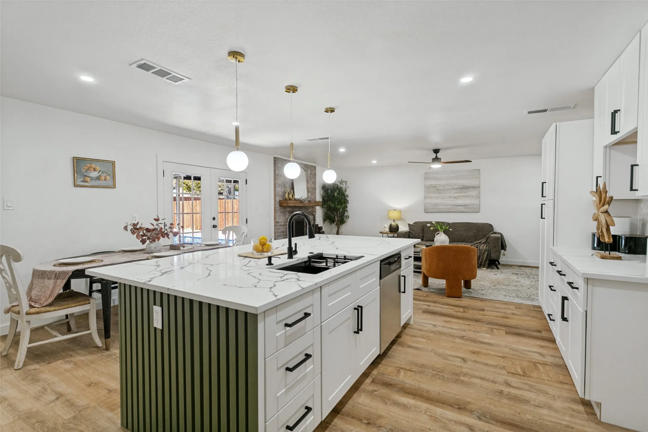 Kitchen island featuring a white quartz-finish countertop, integrated sink with matte black fixture, and green slatted base