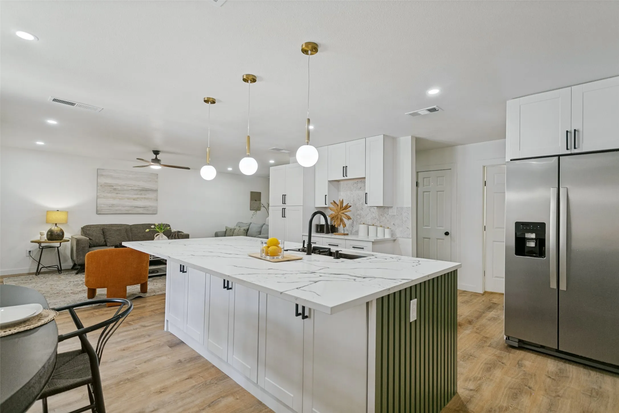 Kitchen island featuring a white countertop with dark veining, integrated sink, and matte black faucet