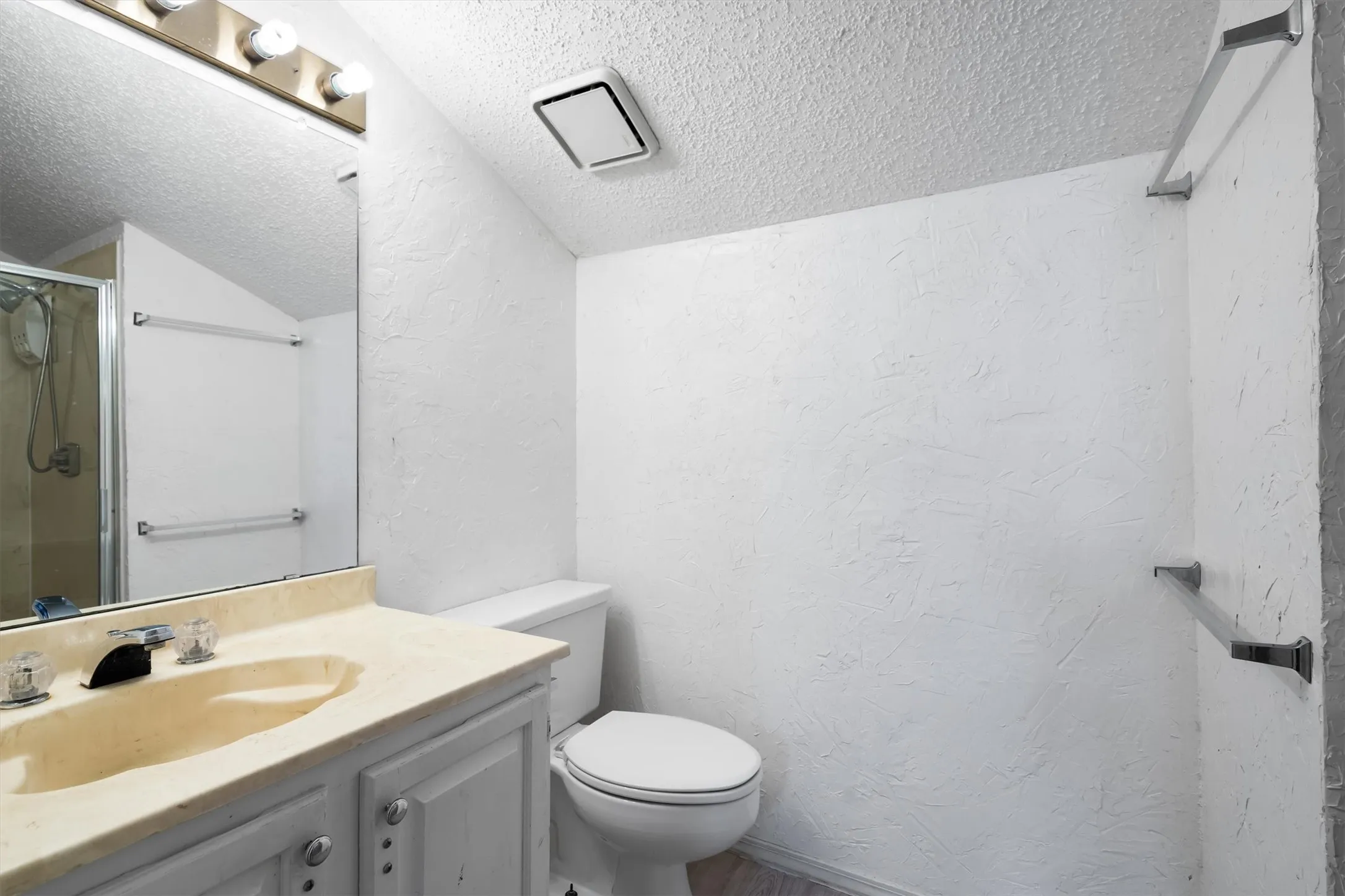 Vanity with an integrated sink, polished chrome faucet, and storage cabinetry