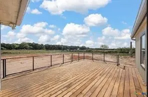 Expansive wood-plank deck with a black metal railing, offering extended outdoor living space