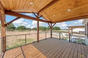 Covered porch featuring wood-finish decking, exposed wood beams, and recessed lighting