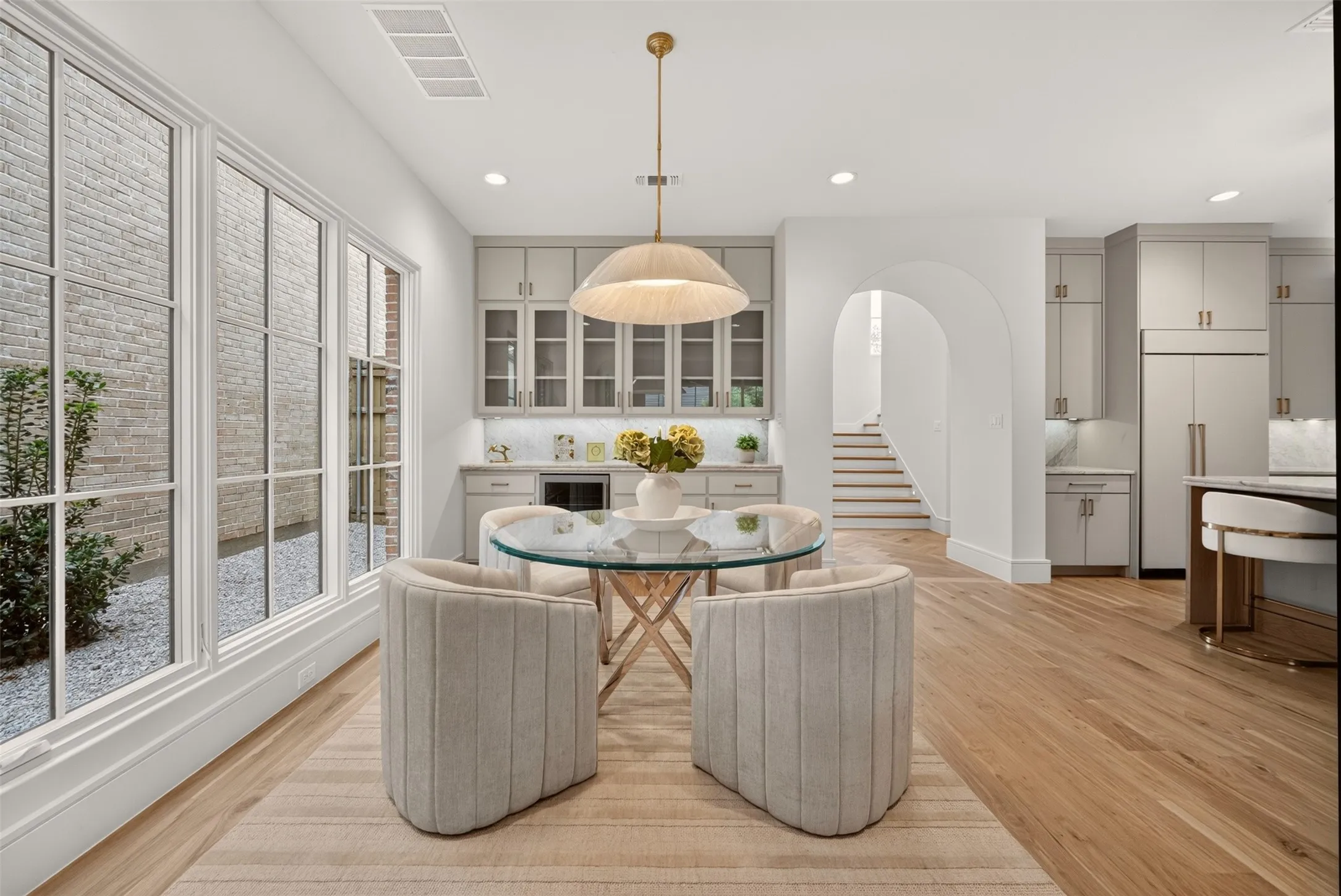 Expansive wood-finish flooring throughout, complemented by large paneled windows