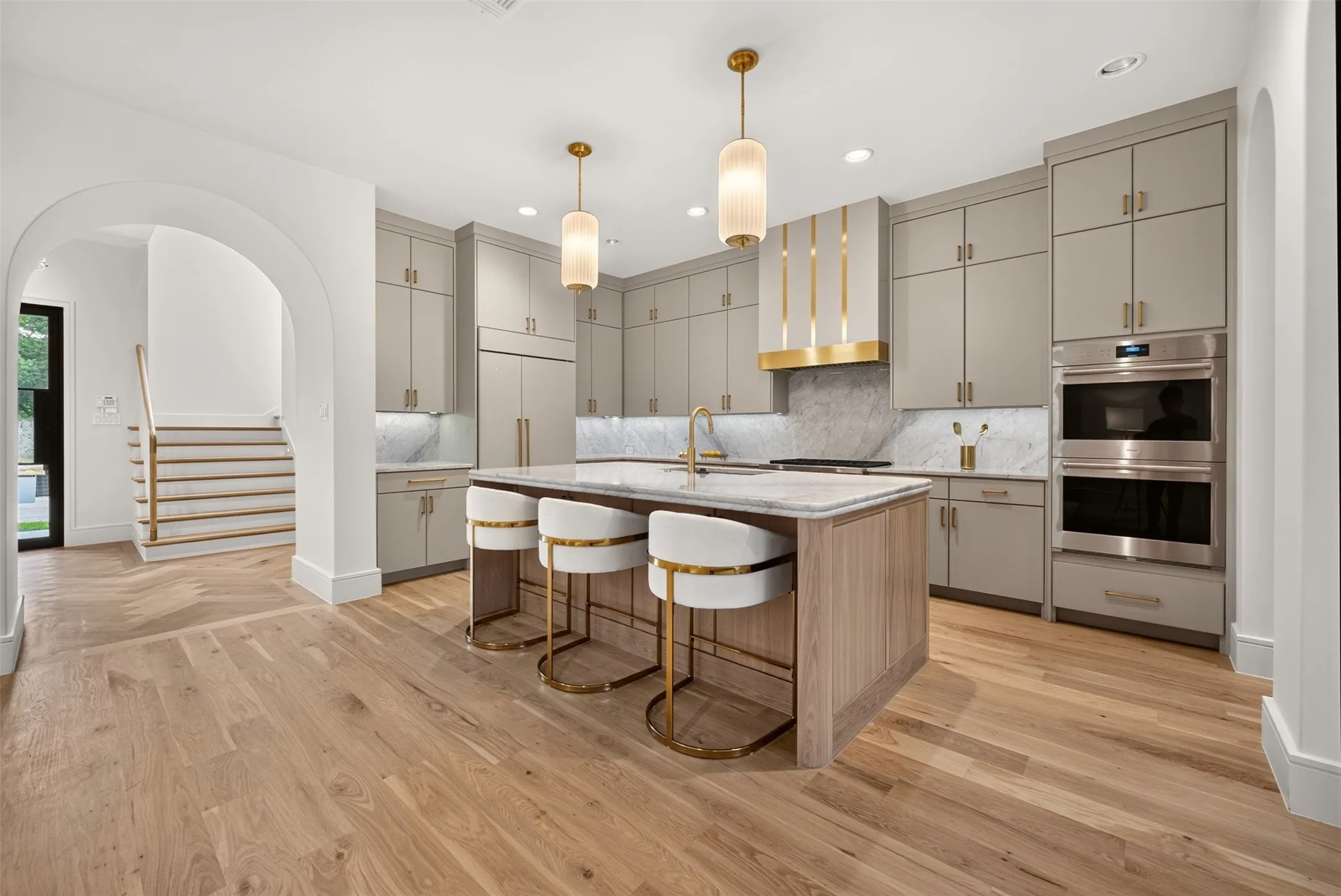 Gourmet kitchen with custom cabinetry, integrated appliances, and a central island featuring a stone countertop