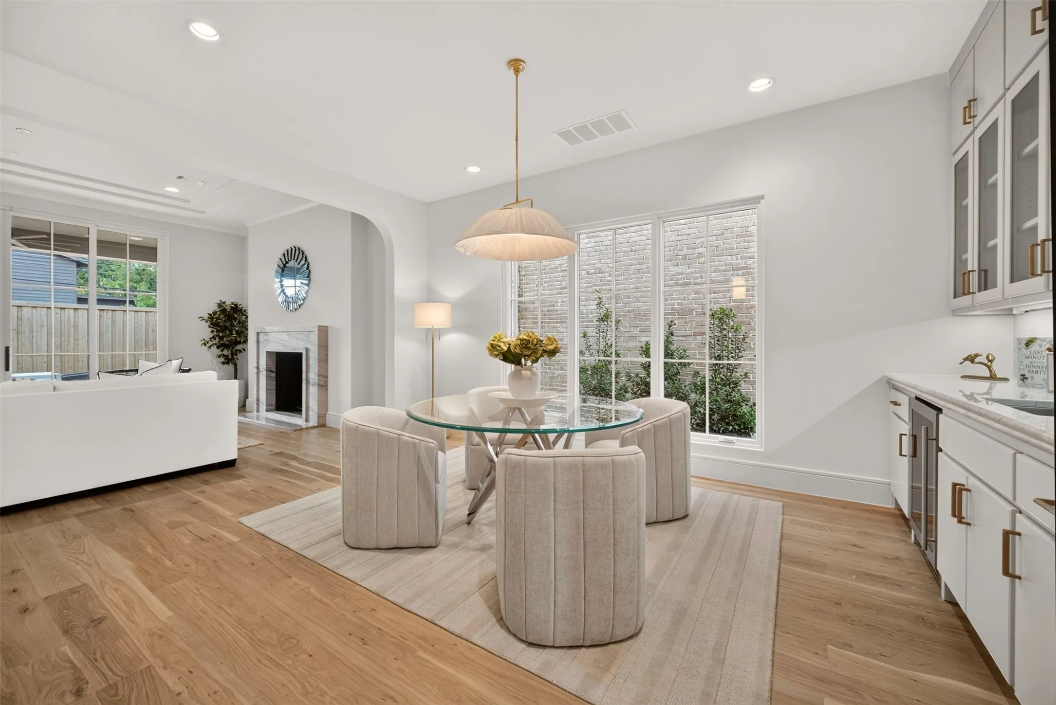 Hardwood flooring, recessed lighting, built-in wet bar with beverage refrigerator, and an arched entryway
