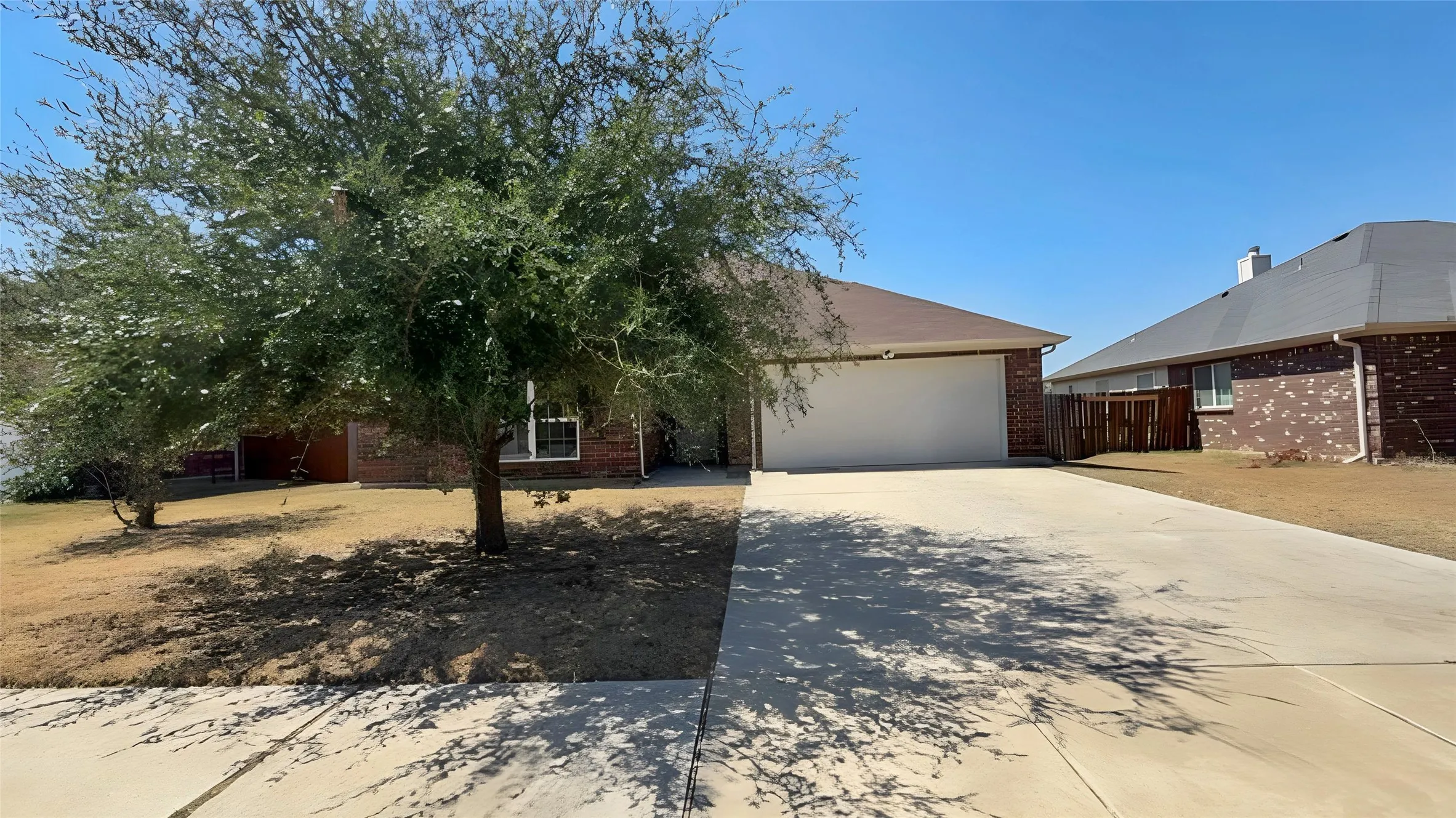 Brick exterior with a two-car garage and concrete driveway