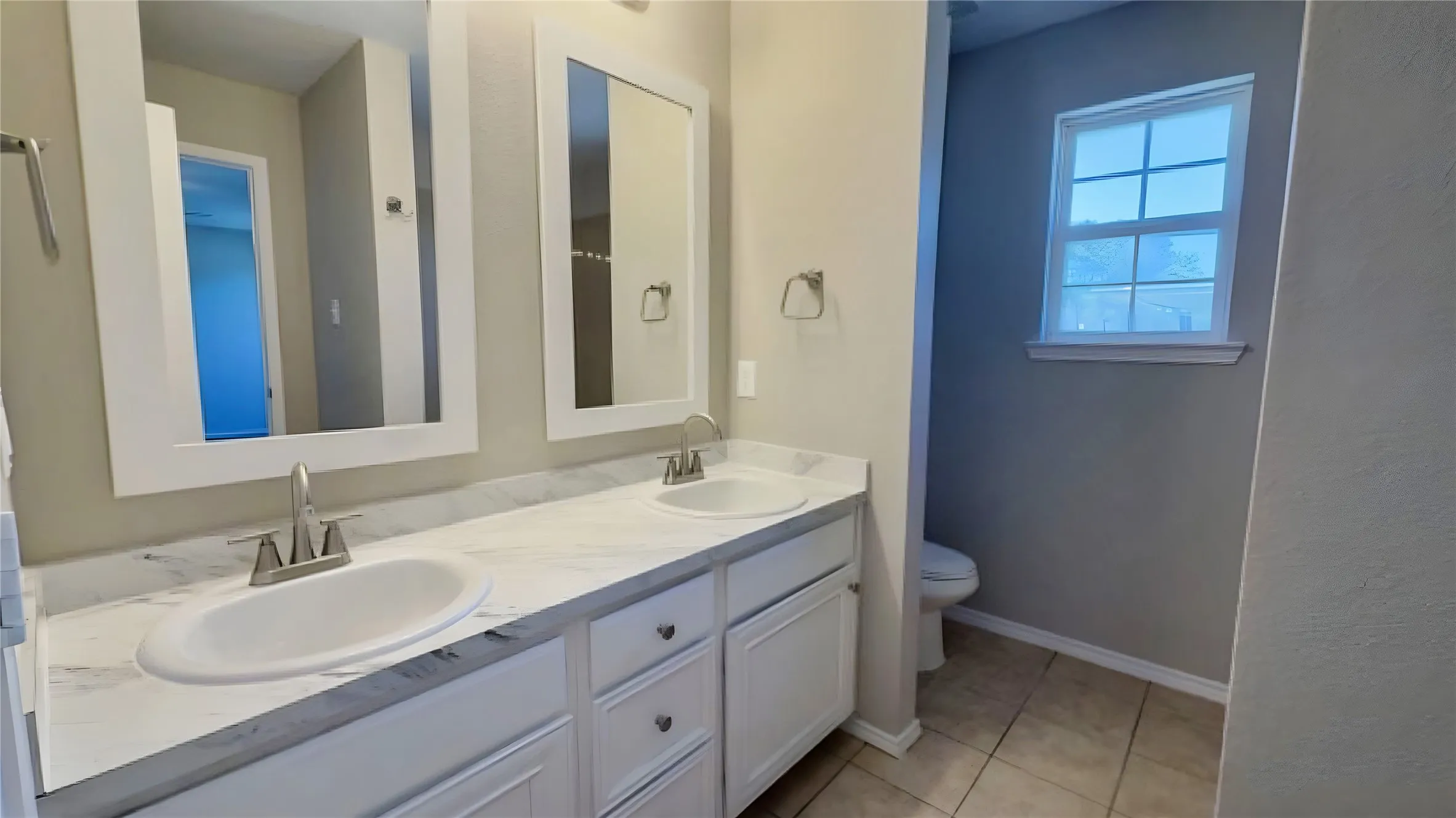 Dual vanity with undermount sinks, white cabinetry, and brushed nickel fixtures