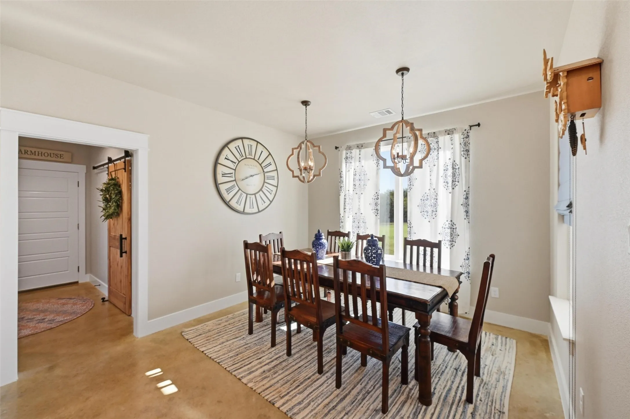 Dining area with a barn door, finished concrete floors, and a chandelier