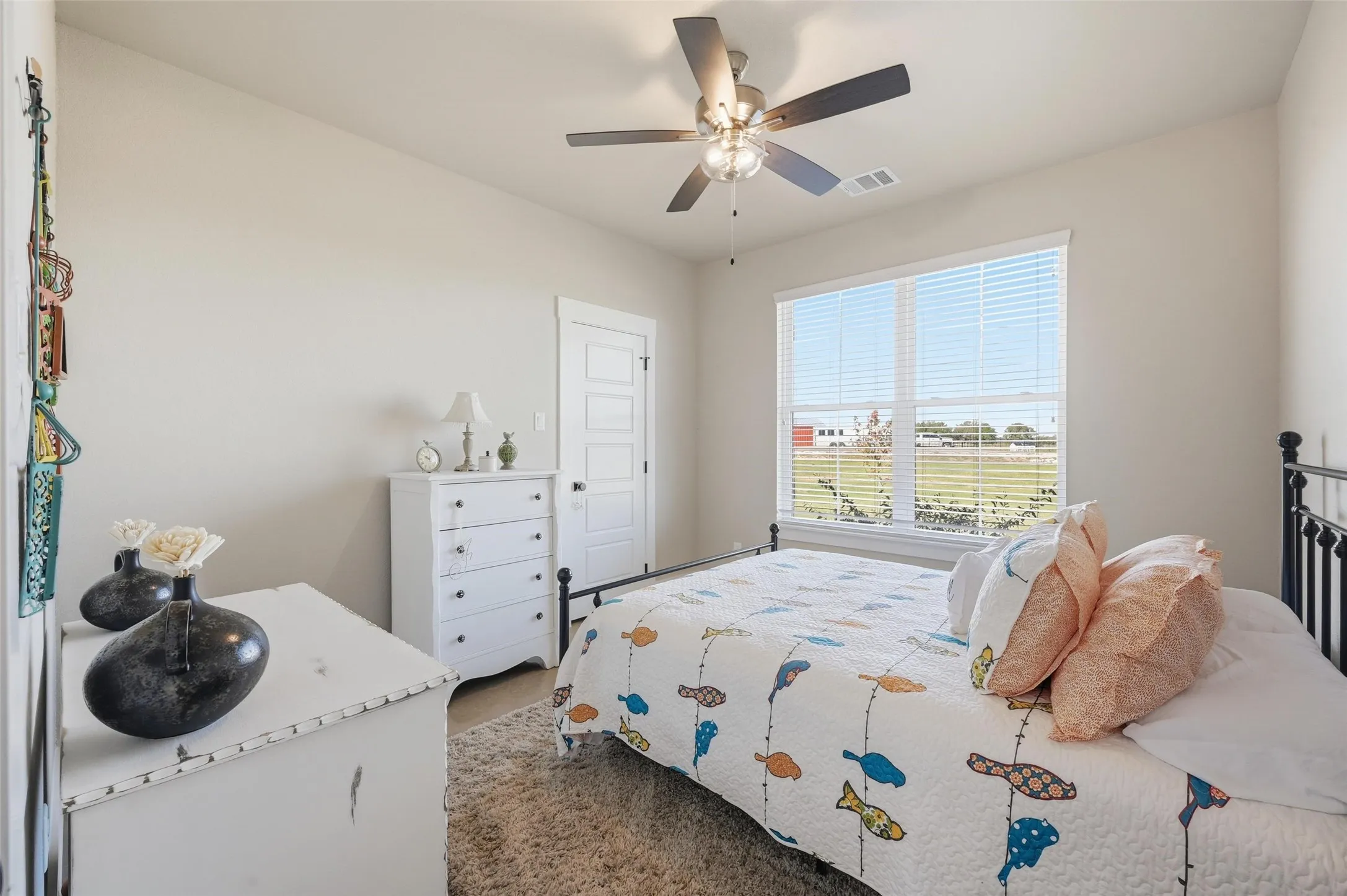 Carpeted bedroom featuring ceiling fan