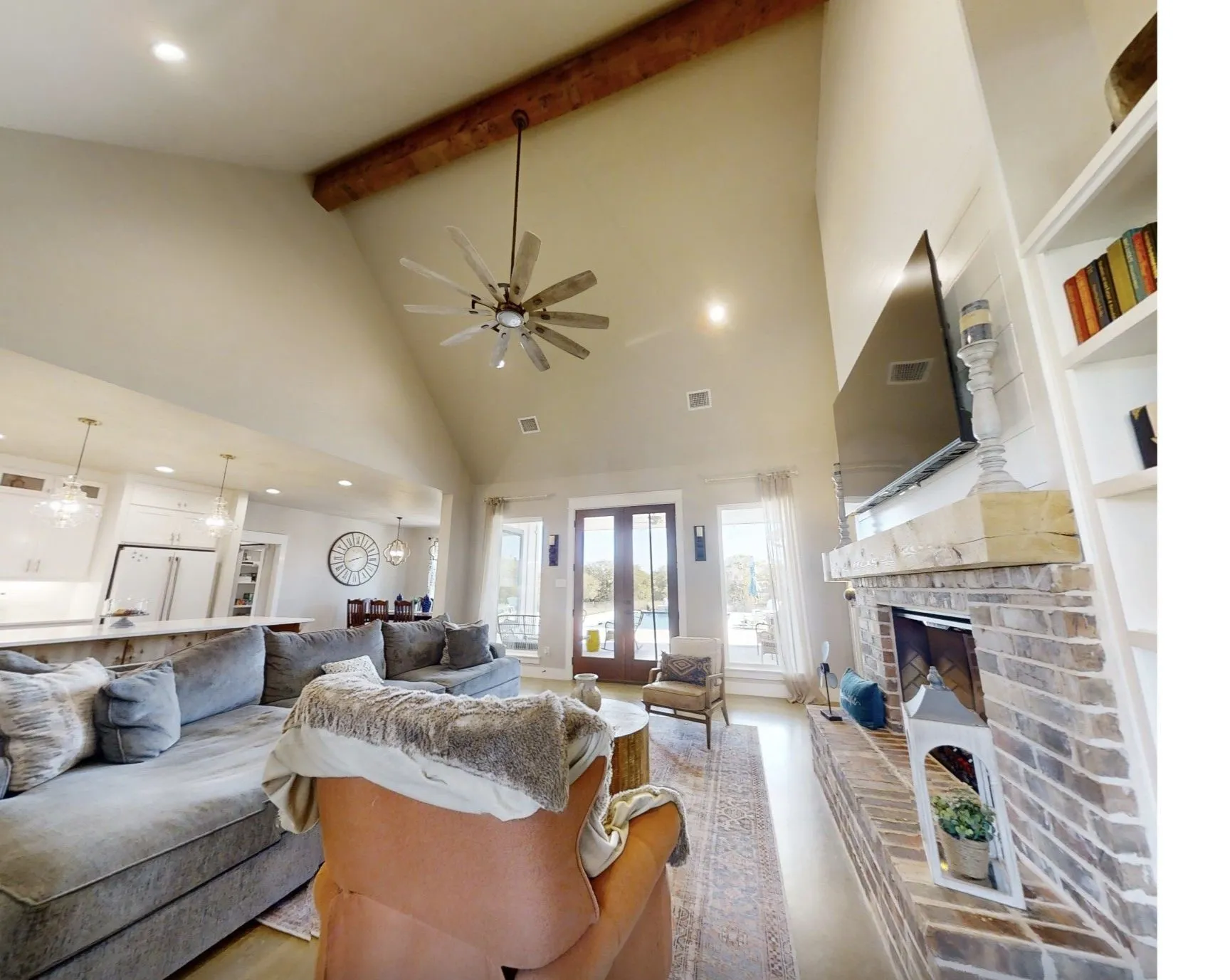 Living area with high vaulted ceiling, recessed lighting, ceiling fan, beamed ceiling, and a brick fireplace