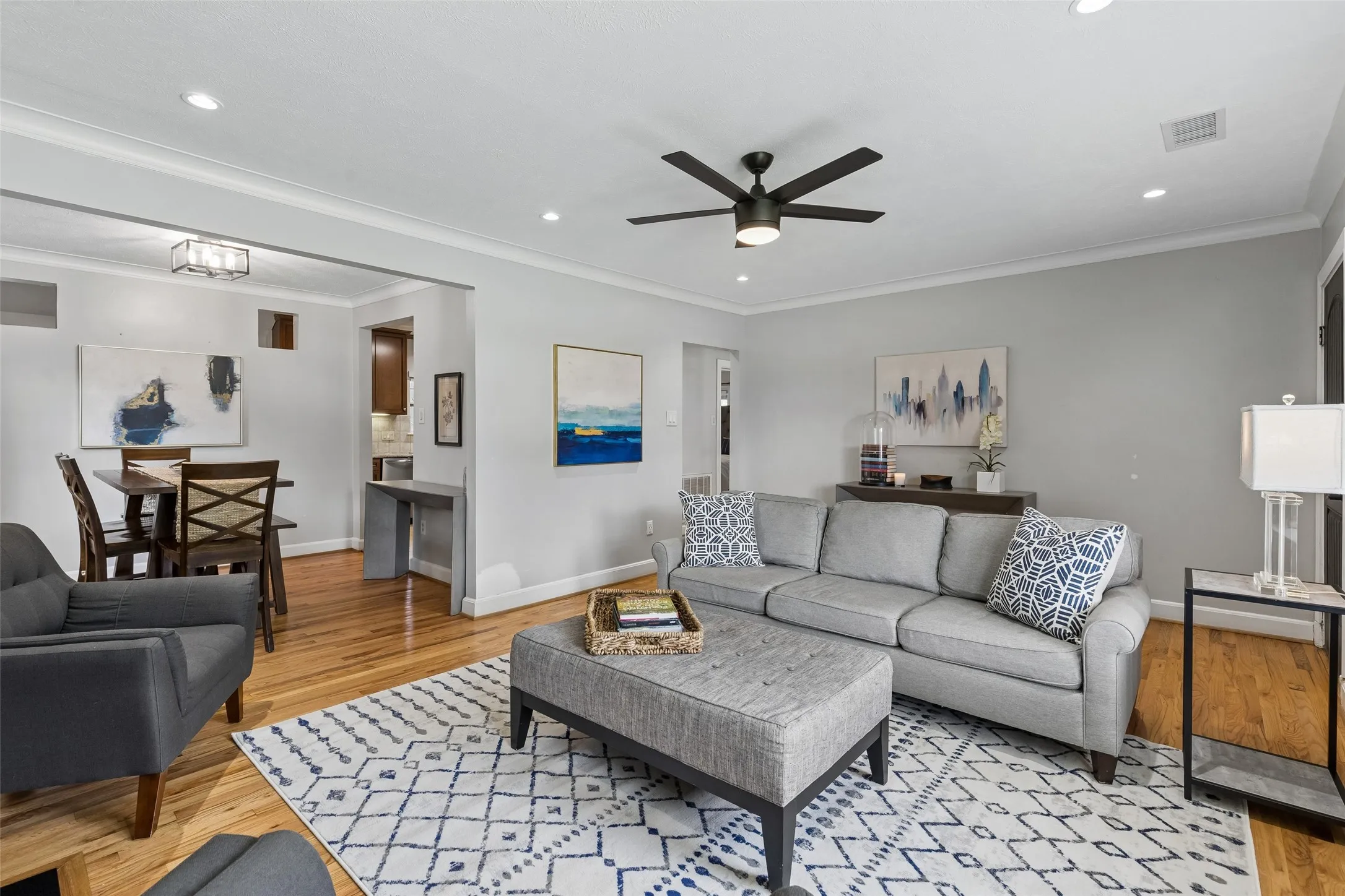 Hardwood flooring, recessed lighting, crown molding, a ceiling fan, and a contemporary dining light fixture